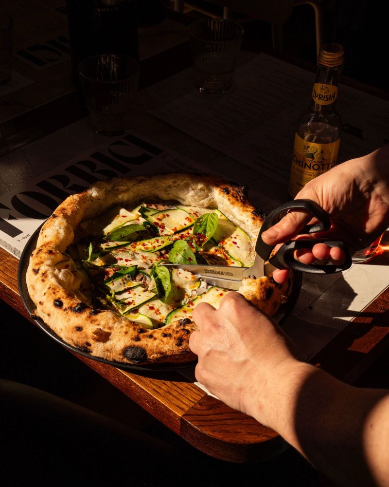 Pizza being cut with scissors