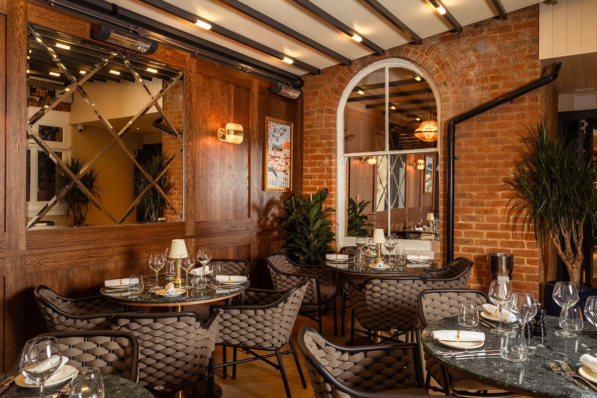 Dining room with exposed brick, wood panelling and mirrored walls