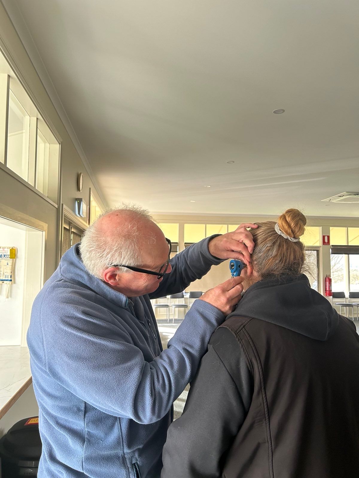 man examining the ear of a woman