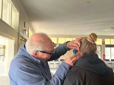 man examining the ear of a woman
