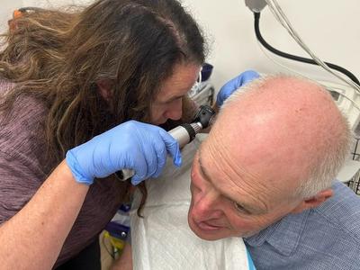 person looking into someones ear.