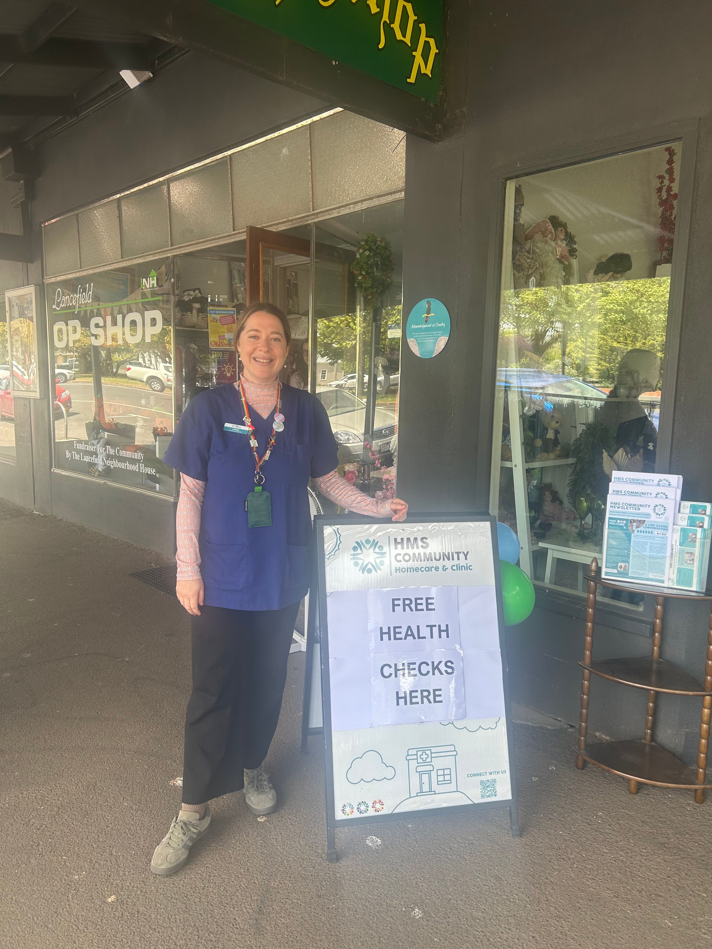 Community Paramedic standing in front of a free health check sign