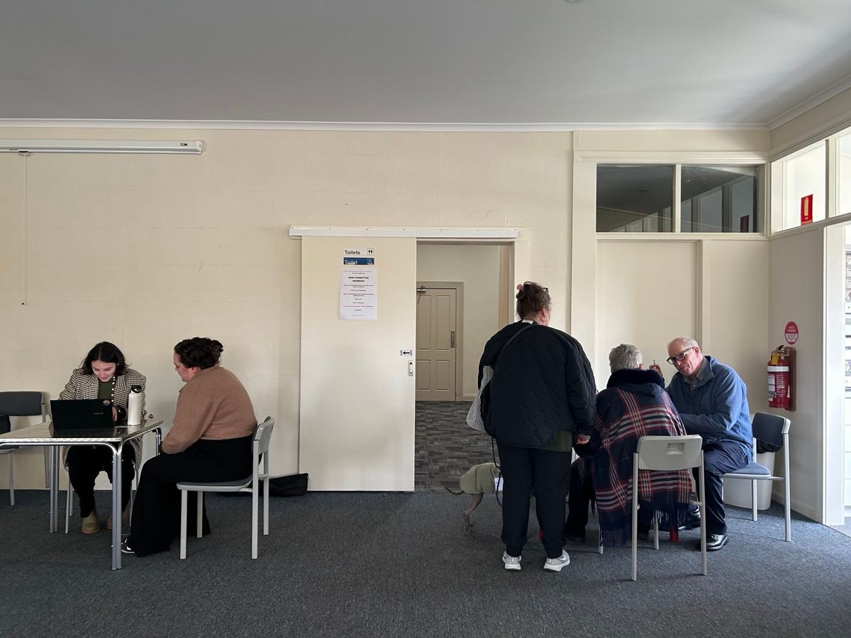 5 people in a room getting health checks at two tables