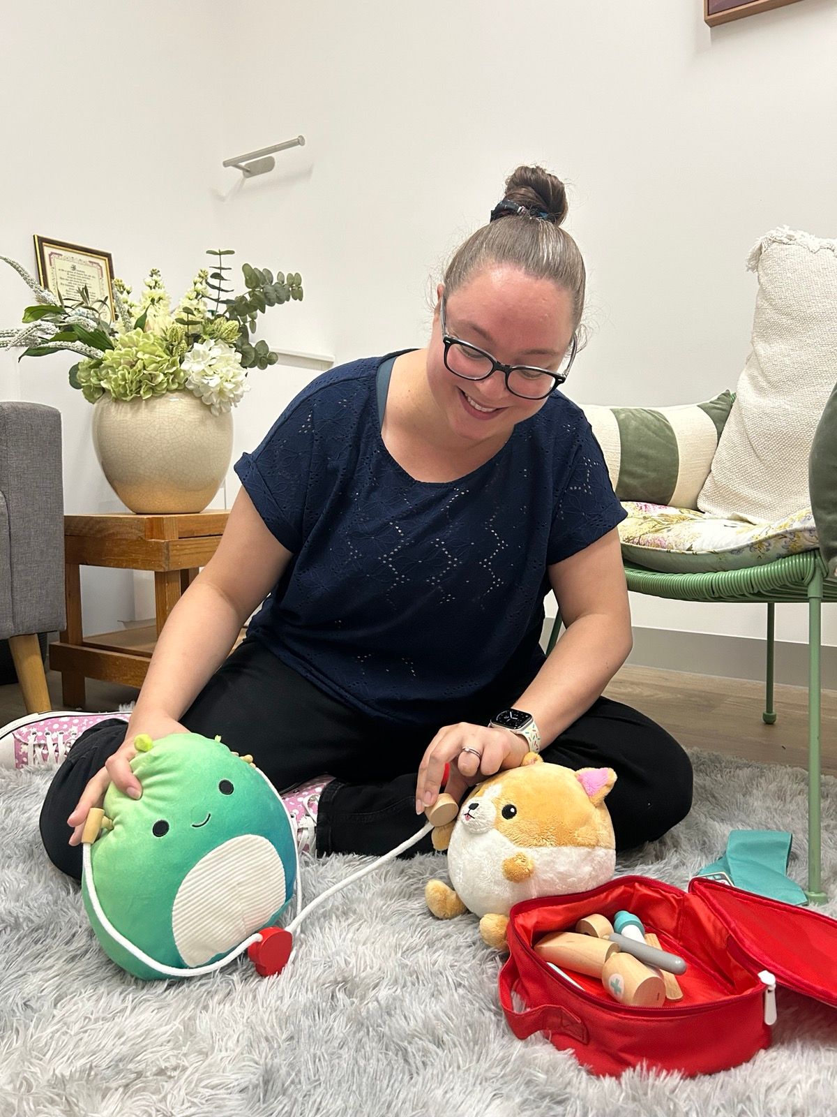 Tracey smiling with toys on the ground