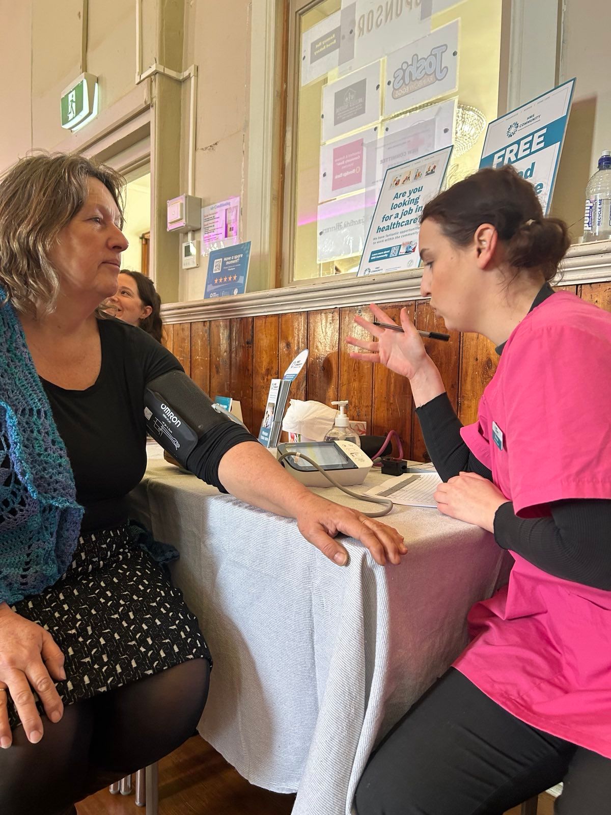 a female getting their blood pressure checked by a paramedic