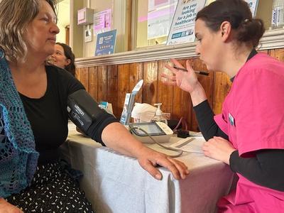 a female getting their blood pressure checked by a paramedic