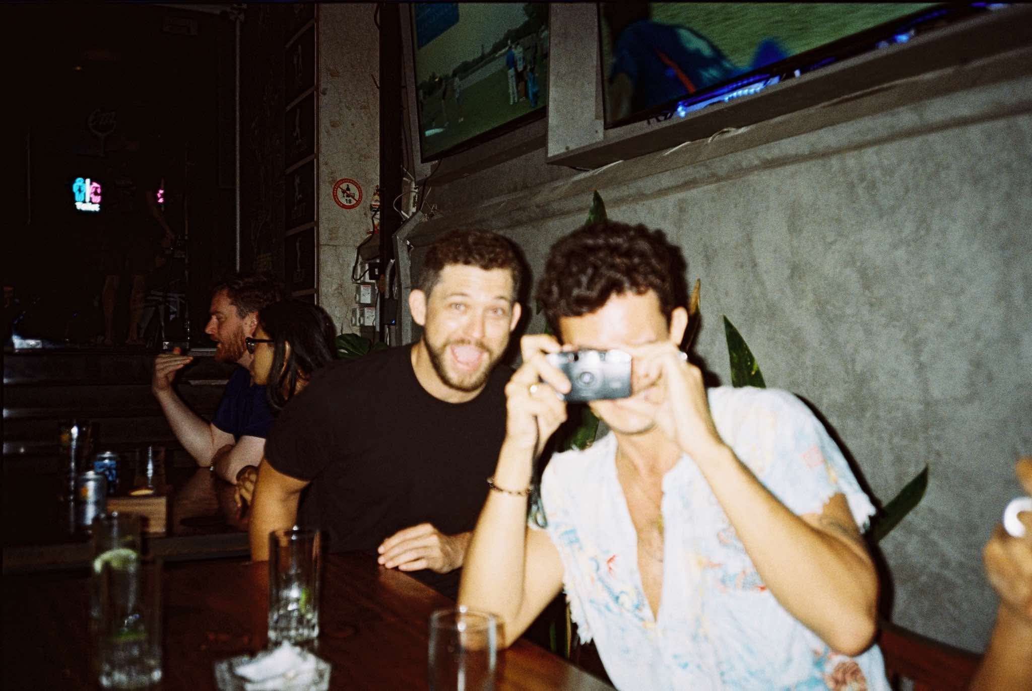 two people at a bar taking photos 