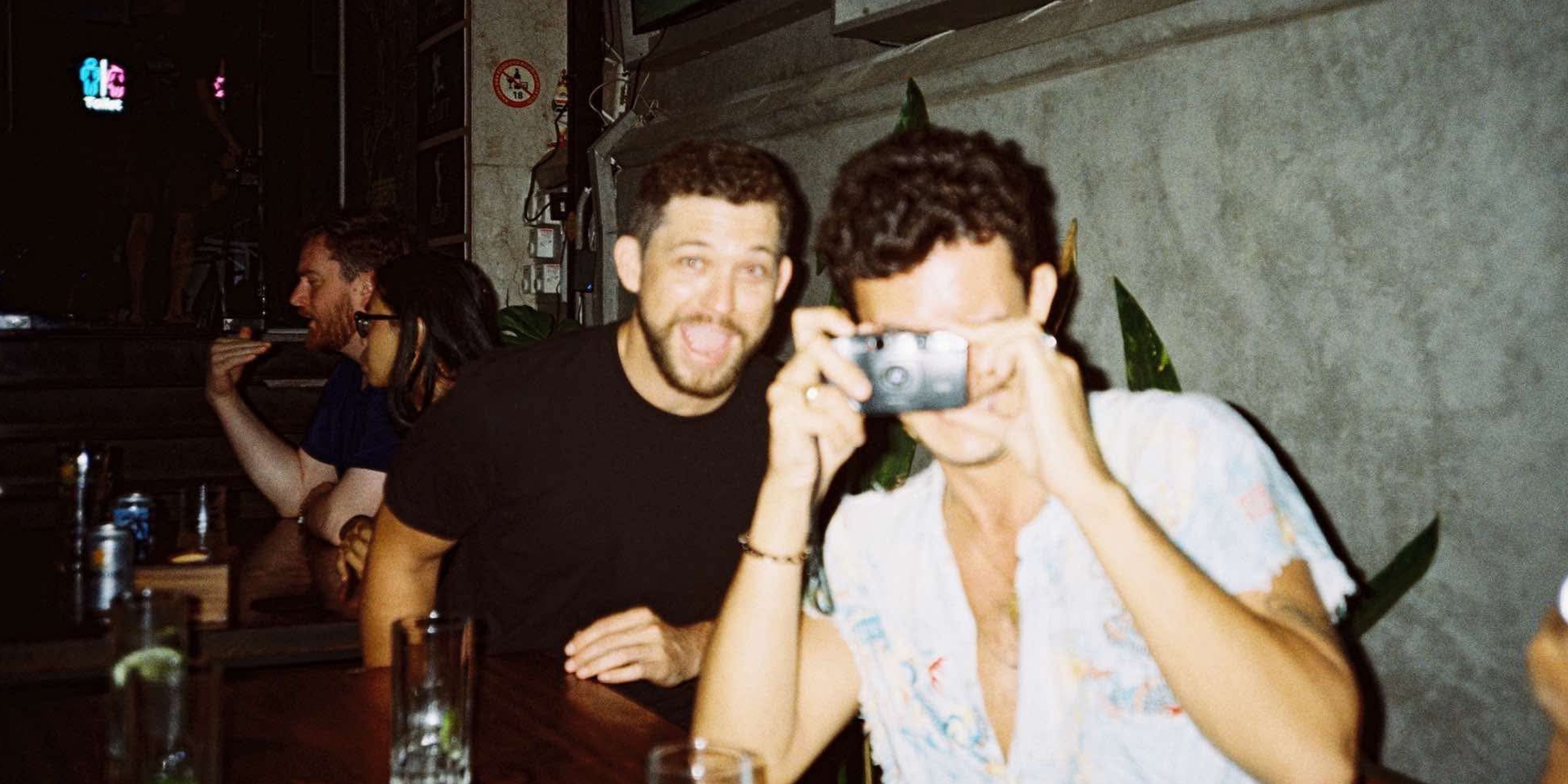 two people at a bar taking photos
