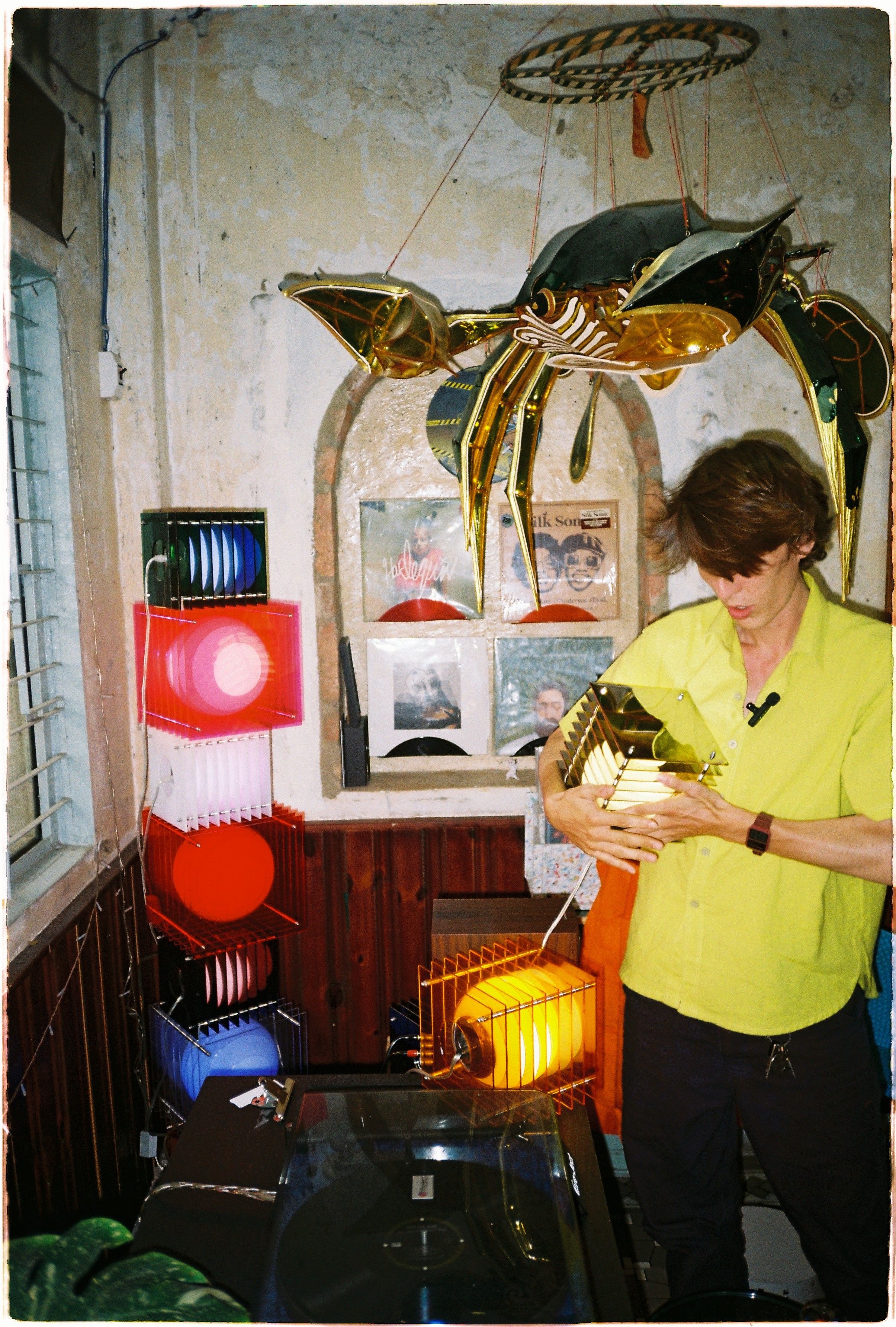 THOMAS bang holding his lamp in neo cafe 