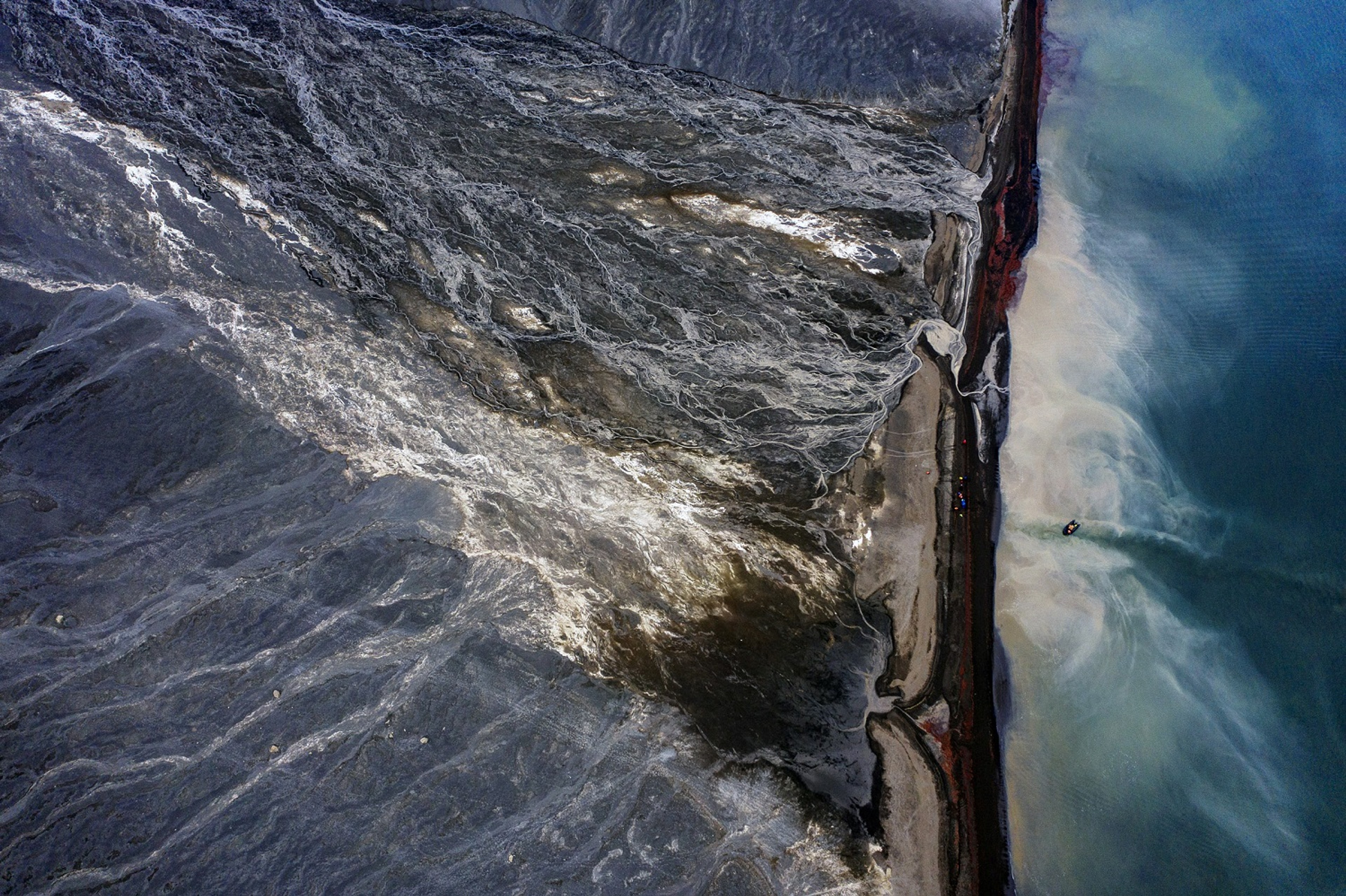 A drone shot of Deception Island, looking down on a Zodiac approaching the beach/Benn Berkeley