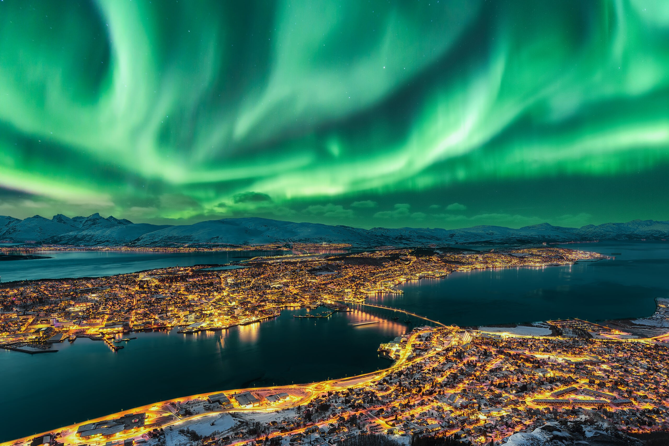 Aurora Borealis dancing over the urban skyline of Tromsø, Norway/Getty Images