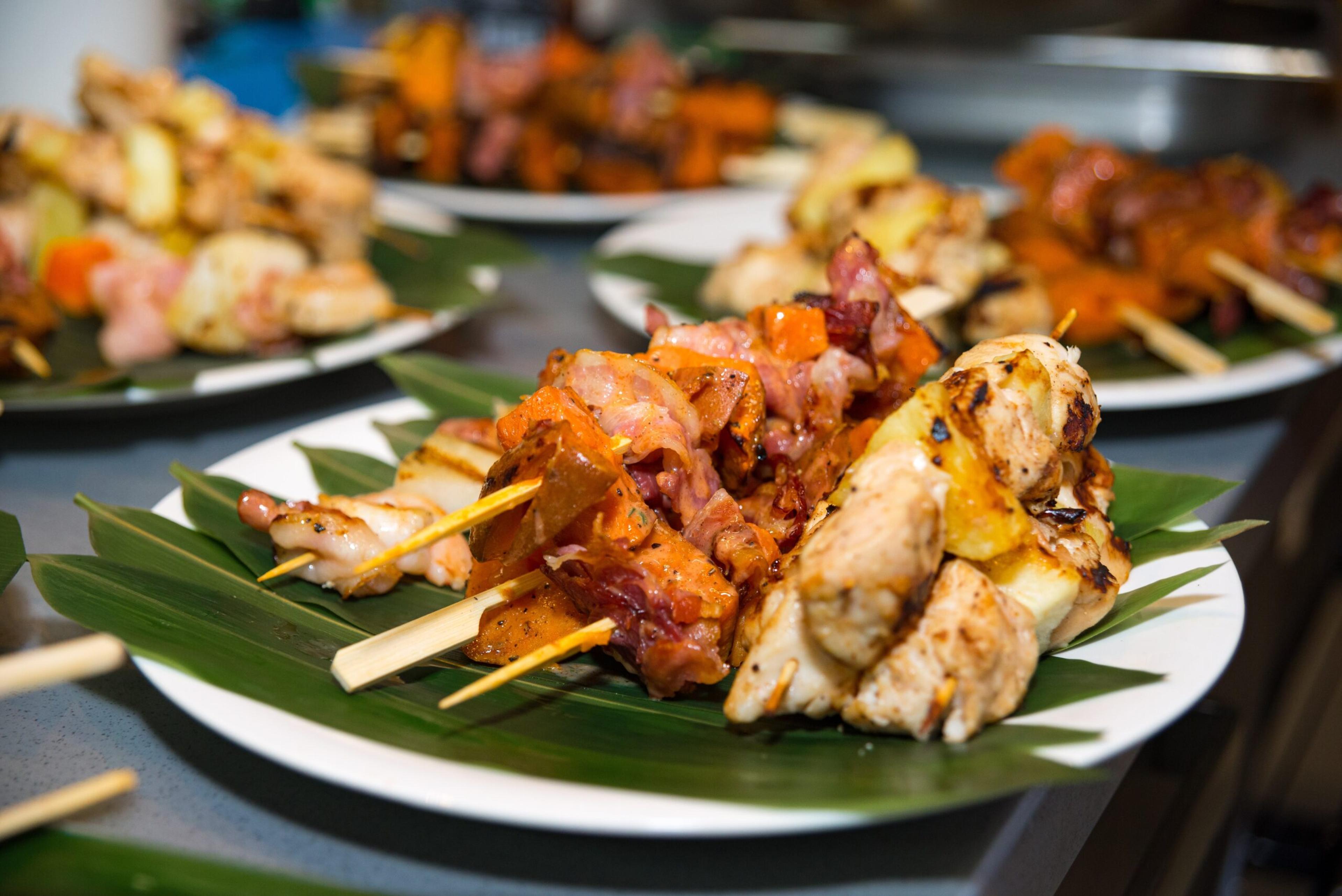Caribbean-style kebabs of shrimp, sweet yams, bacon, and chicken fillet on pineapple./Shutterstock