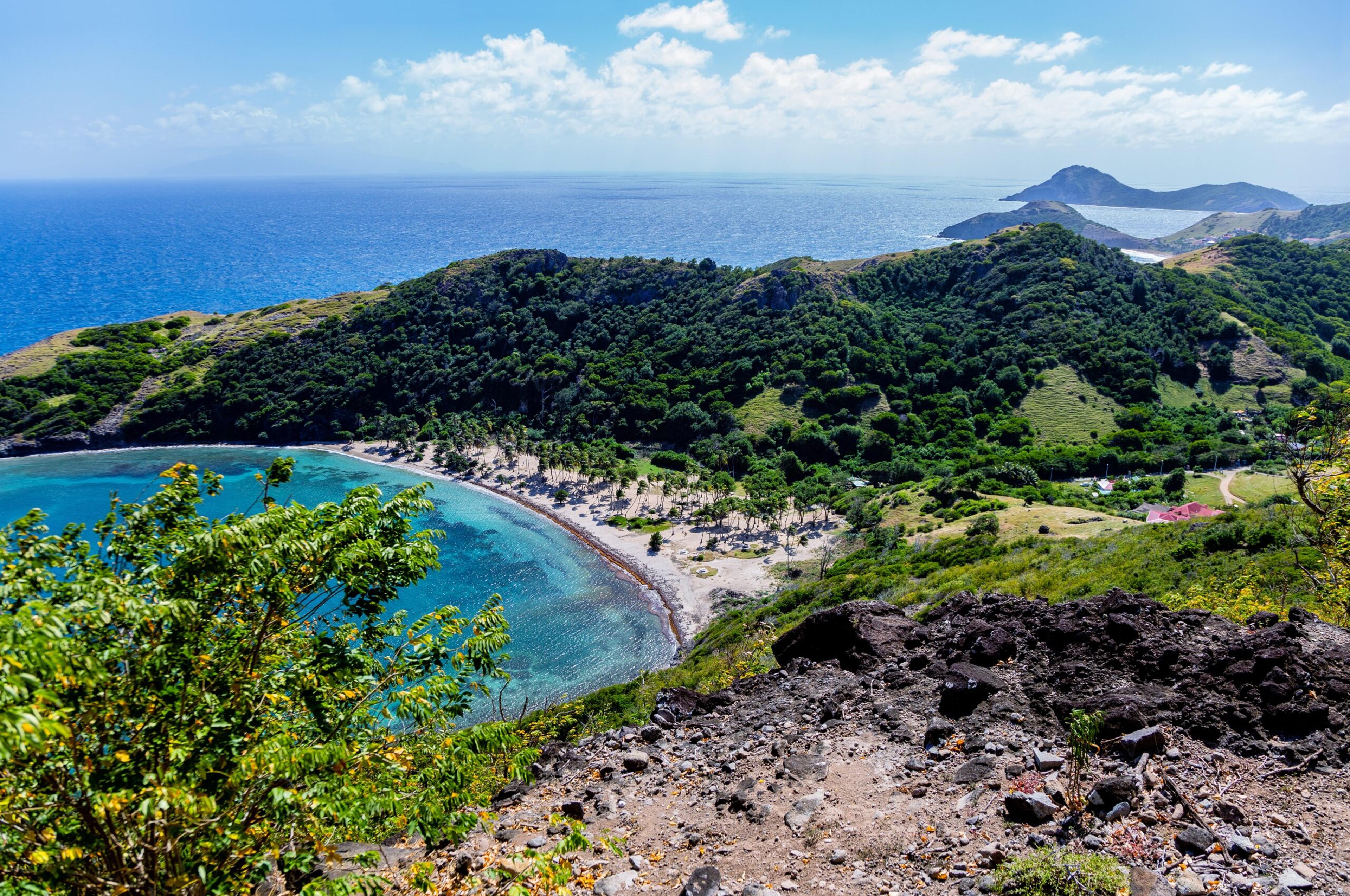 From the Morne Morel hiking trail, you can see the quiet crescent of the Beach Anse Pompierre on the islet of Terre-de-Haut, Guadeloupe./Shutterstock