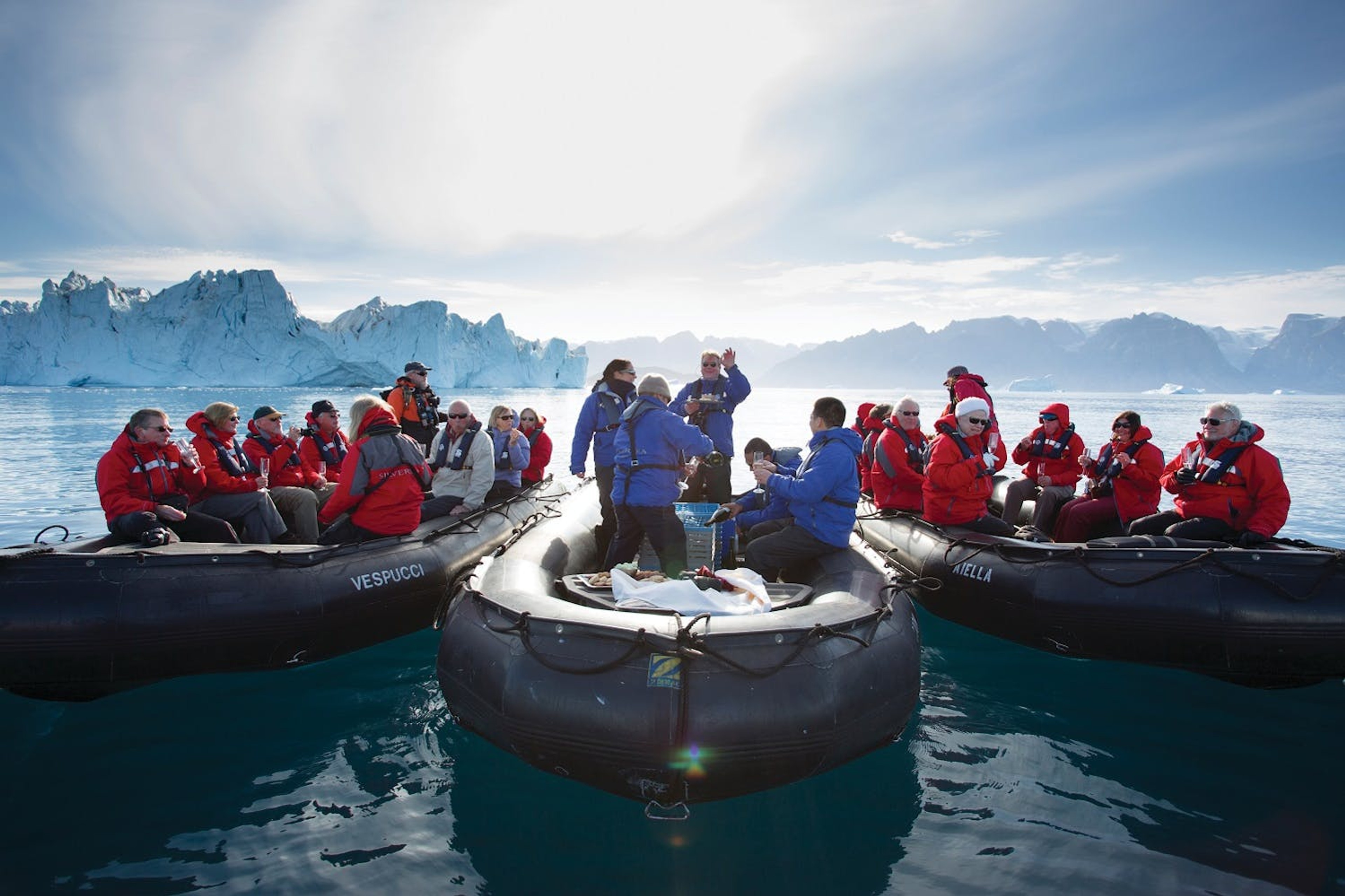 Silversea's expedition team members pull three Zodiacs alongside each other, as guests enjoy a glass of Champagne./Richard Sidey