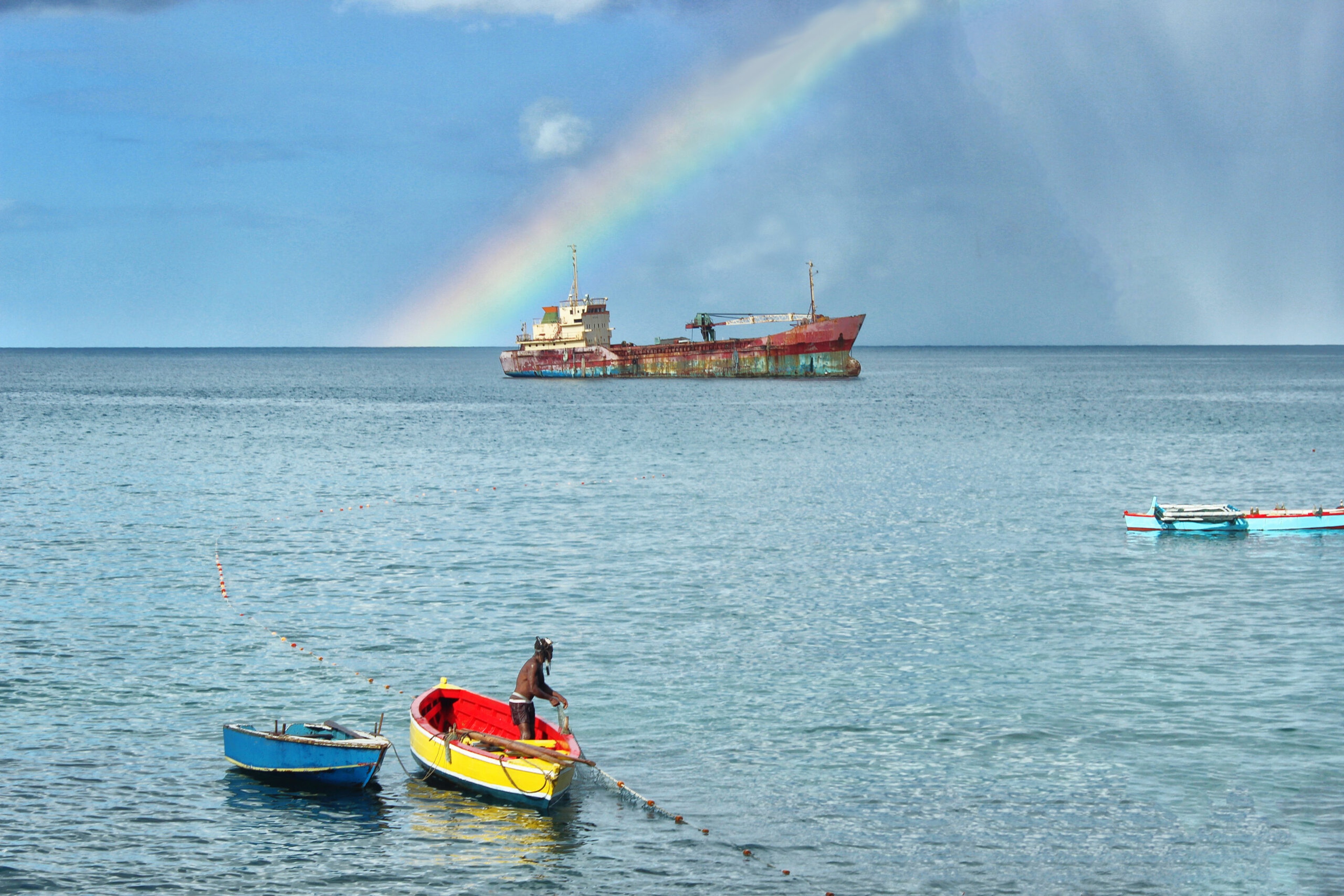 Be on the lookout for rainbows in Grenada. A fisherman is hauling in his net early on a showery morning when a rainbow breaks through on the horizon./Getty Images
