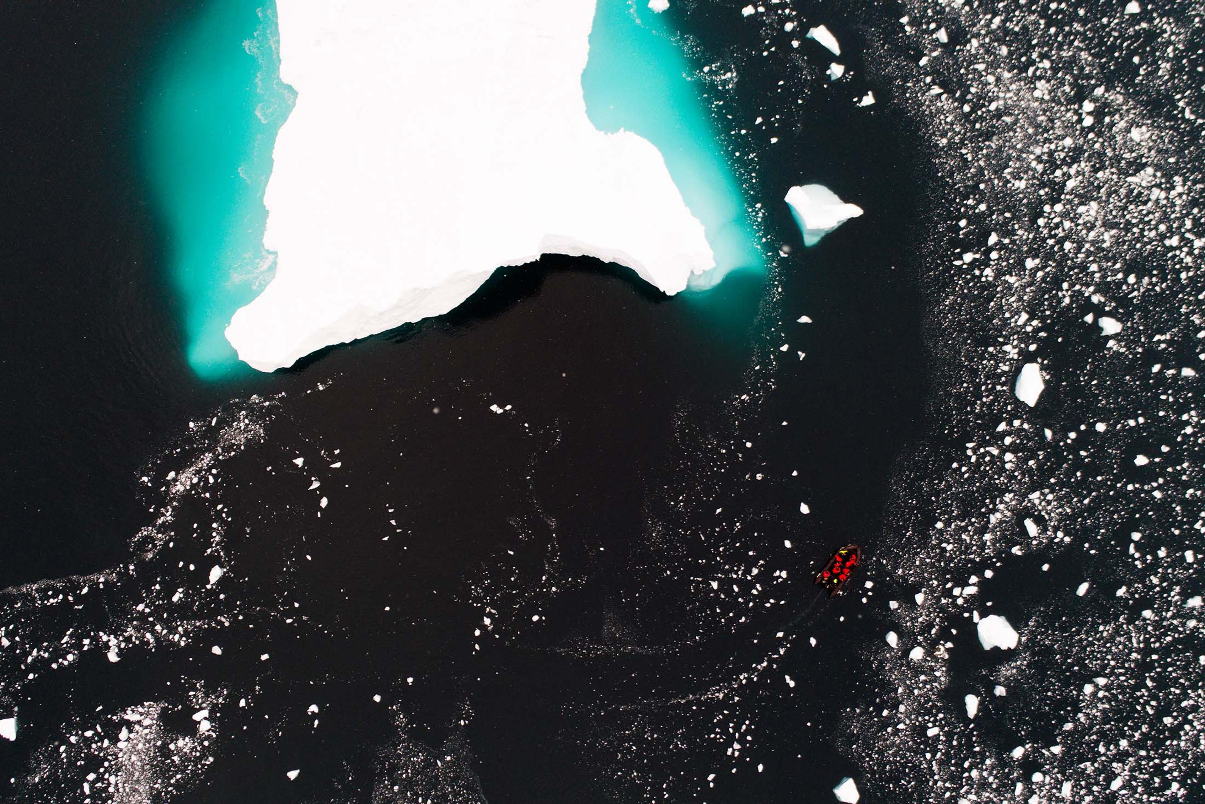 An iceberg dwarfs a Zodiac at Cierva Cove, Antarctica./Denis Elterman