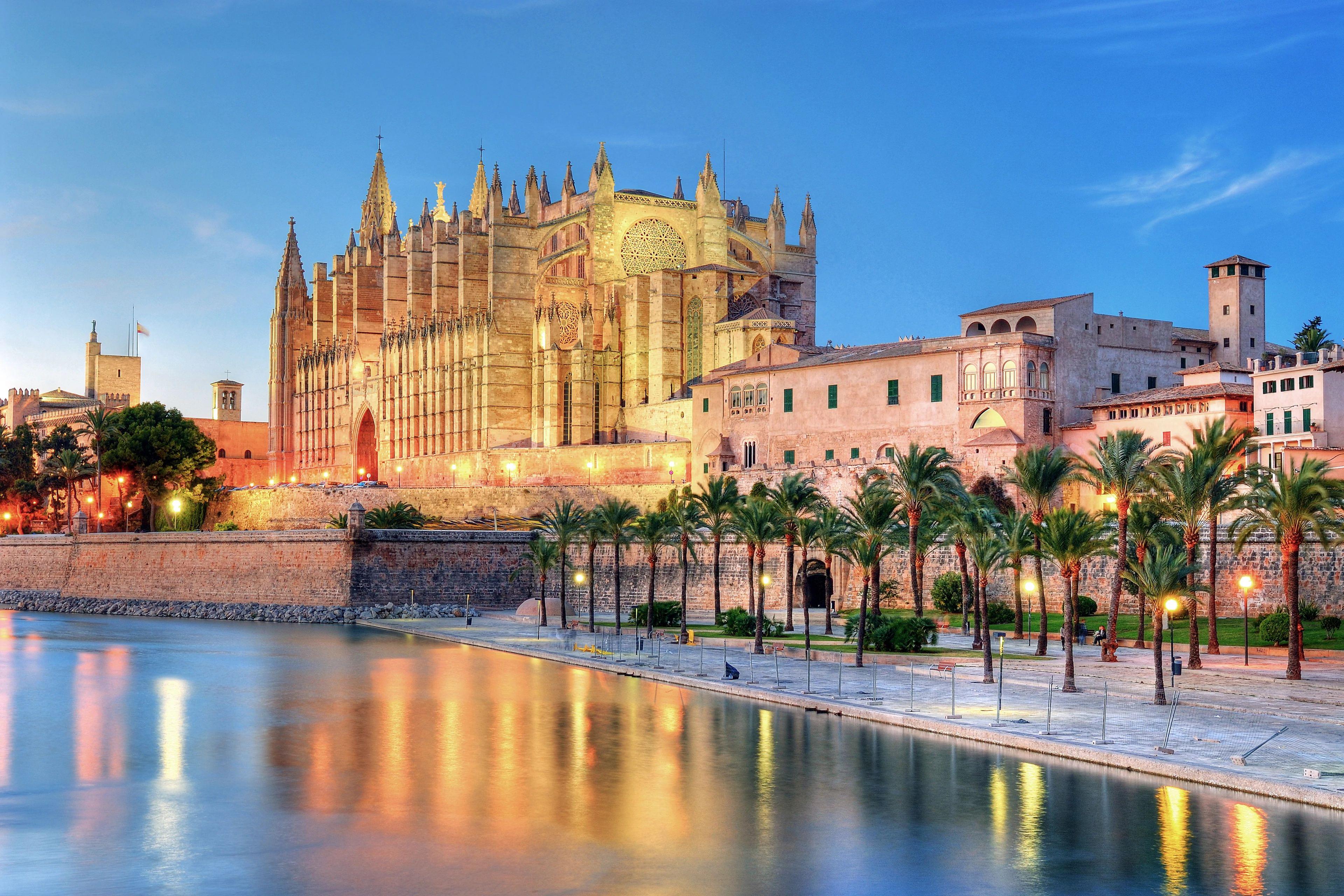 Mallorca historic Palma city architecture overlooking vibrant blue sparkling Mediterranean sea waves. 
