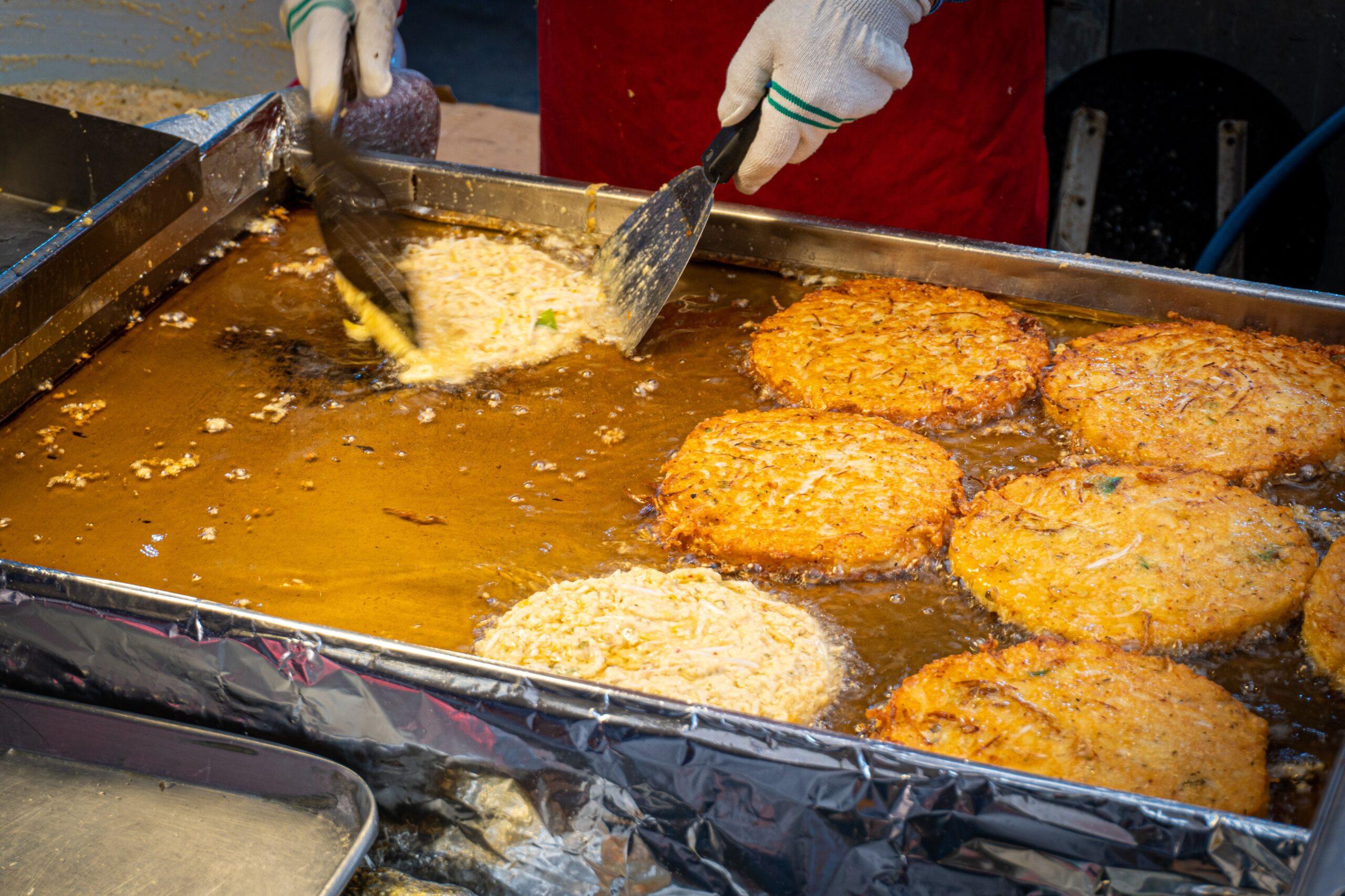 Frying mung bean pancakes, or bindaetteok, in Gwangjang Market, Seoul/ Getty Images
