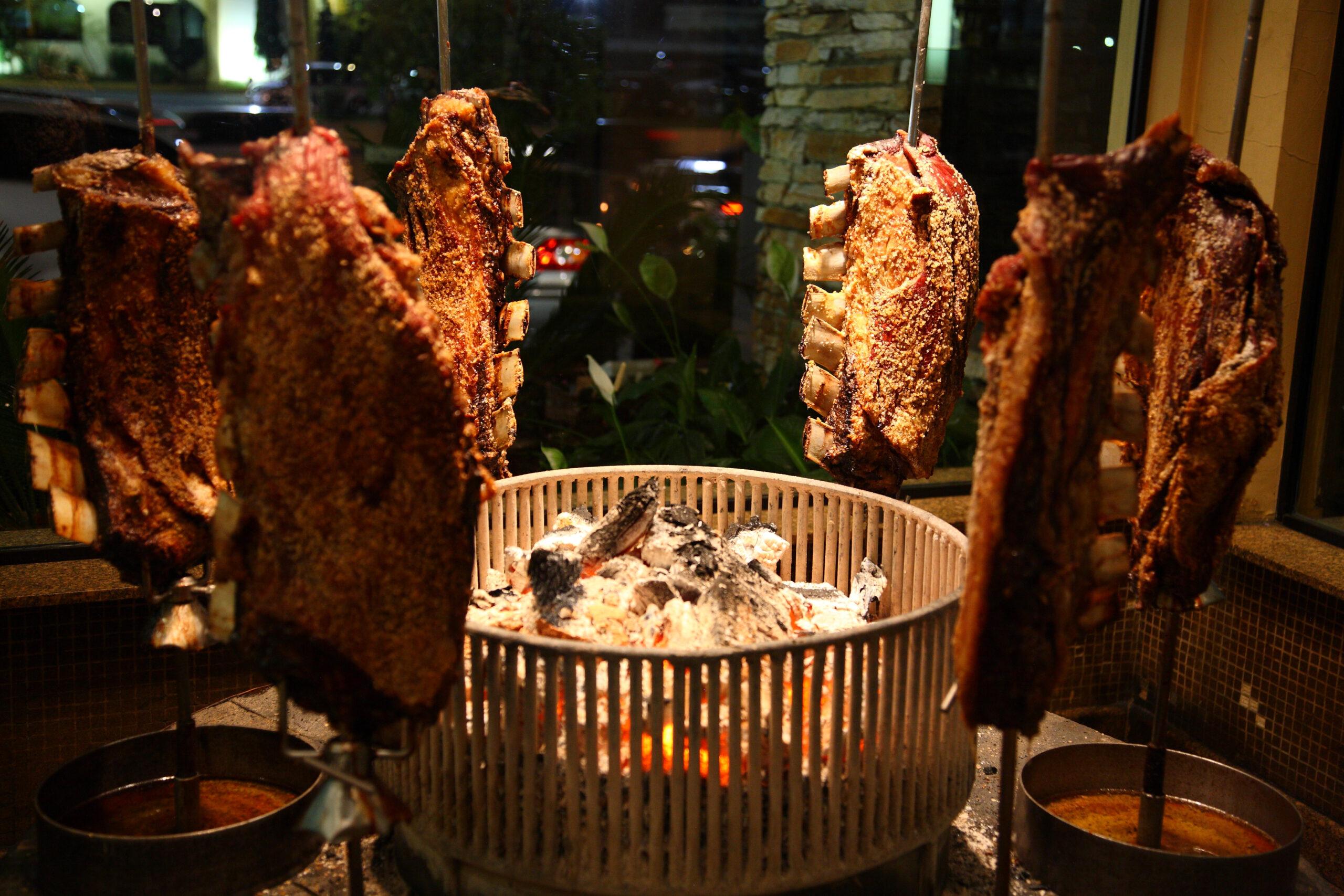 Brazilian style beef ribs on skewers around the grill at a churrascaria steakhouse in Sao Paulo, Brazil./Shutterstock