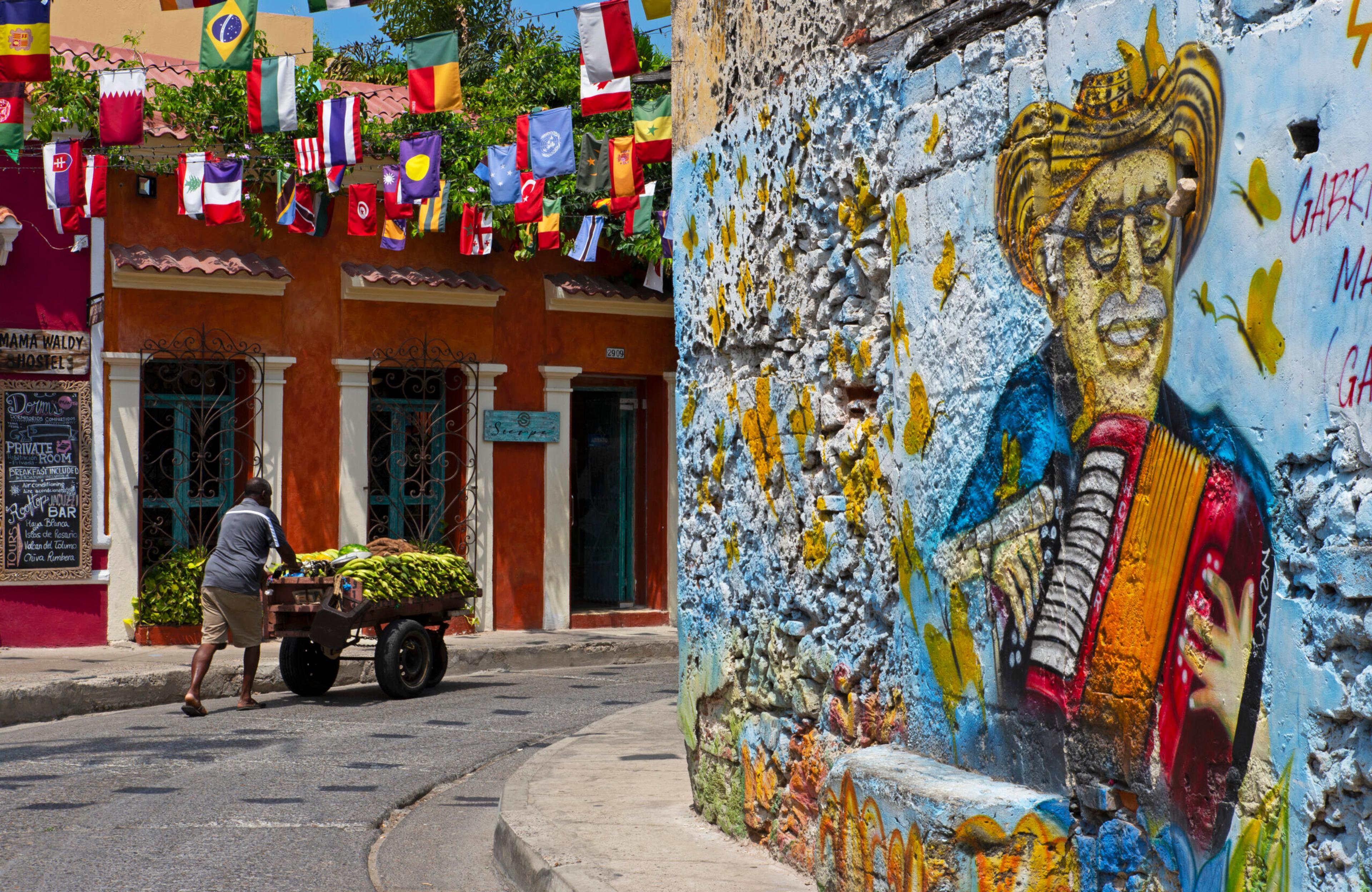 Vendor with his fruit cart in a colorful street in Getsemaní/Getty Images