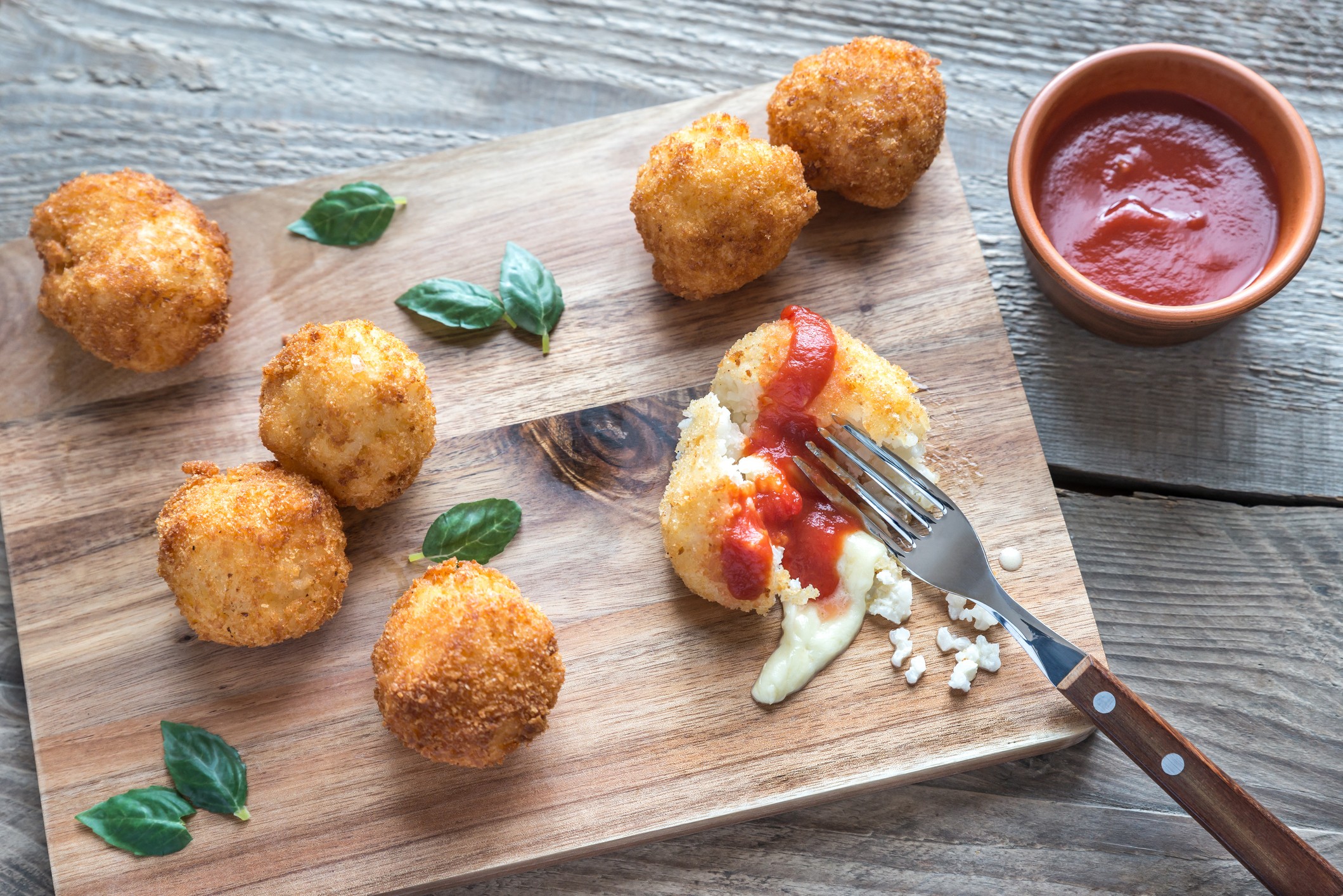 Arancini, fried rice balls filled with various ingredients, are a popular staple in Italy./Getty