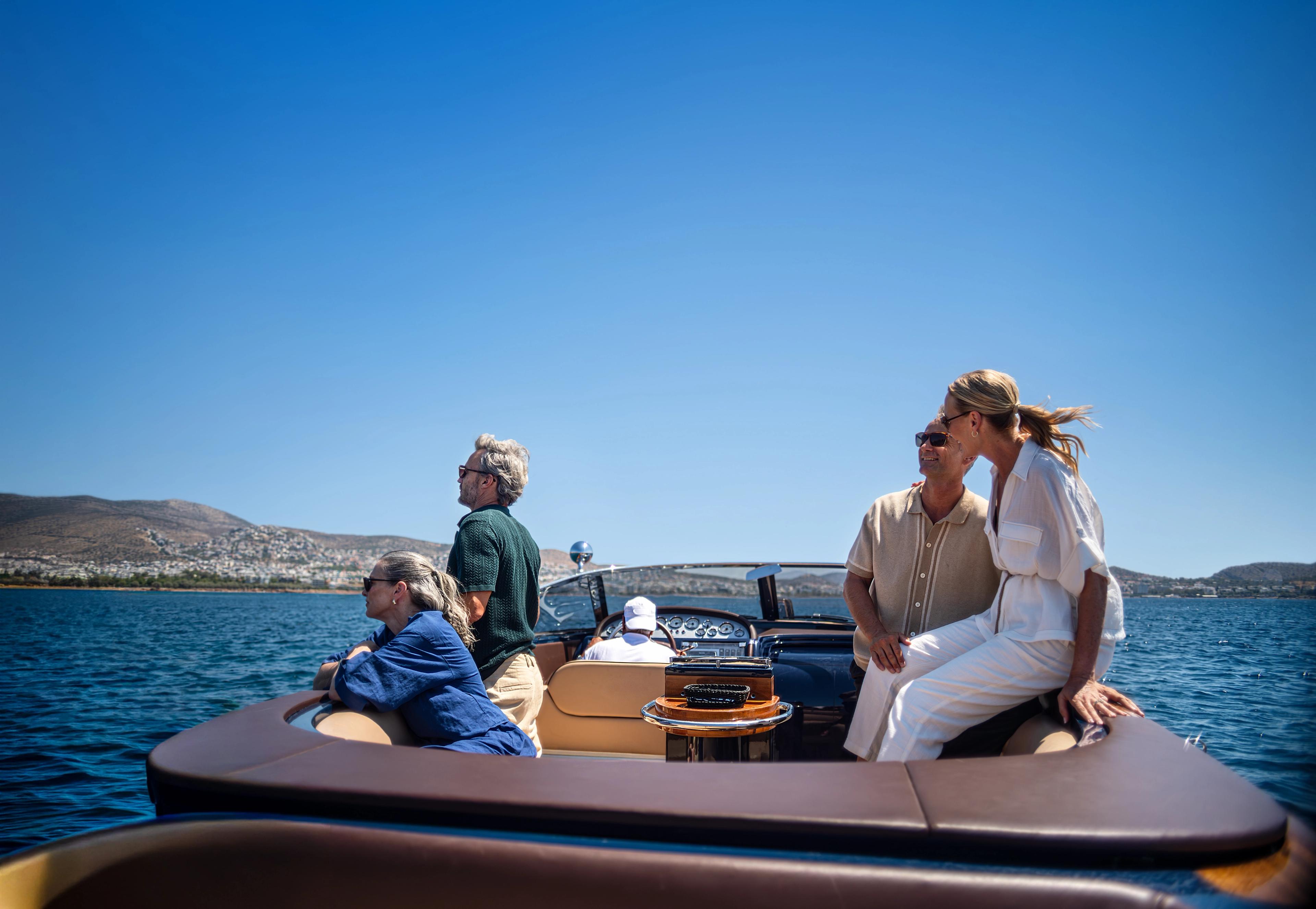 Friends enjoying a scenic luxury boat ride along the sunny Mediterranean coast.