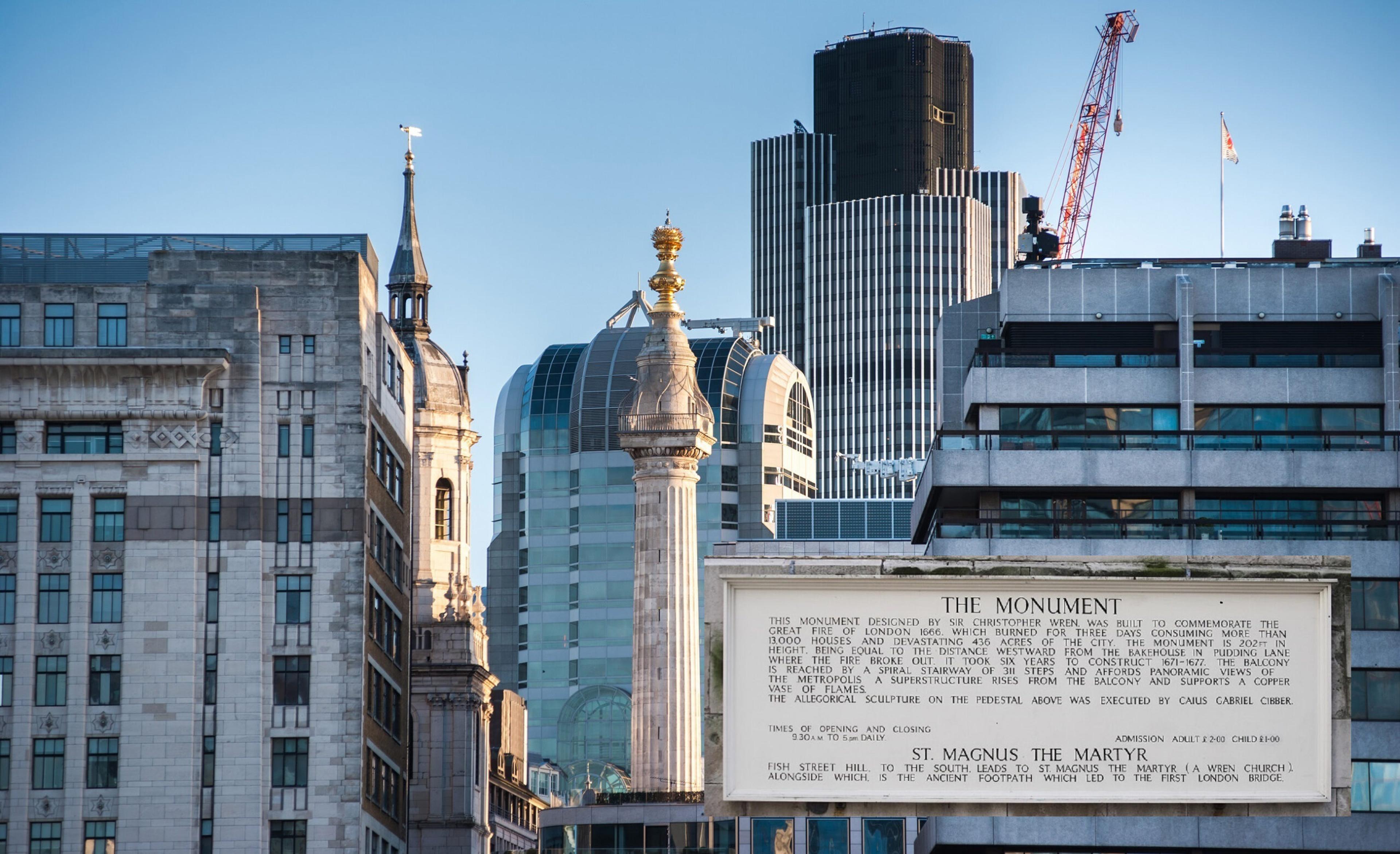 Monument Tower in London at sunrise. Inset photo at right shows inscription on the base./Shutterstock