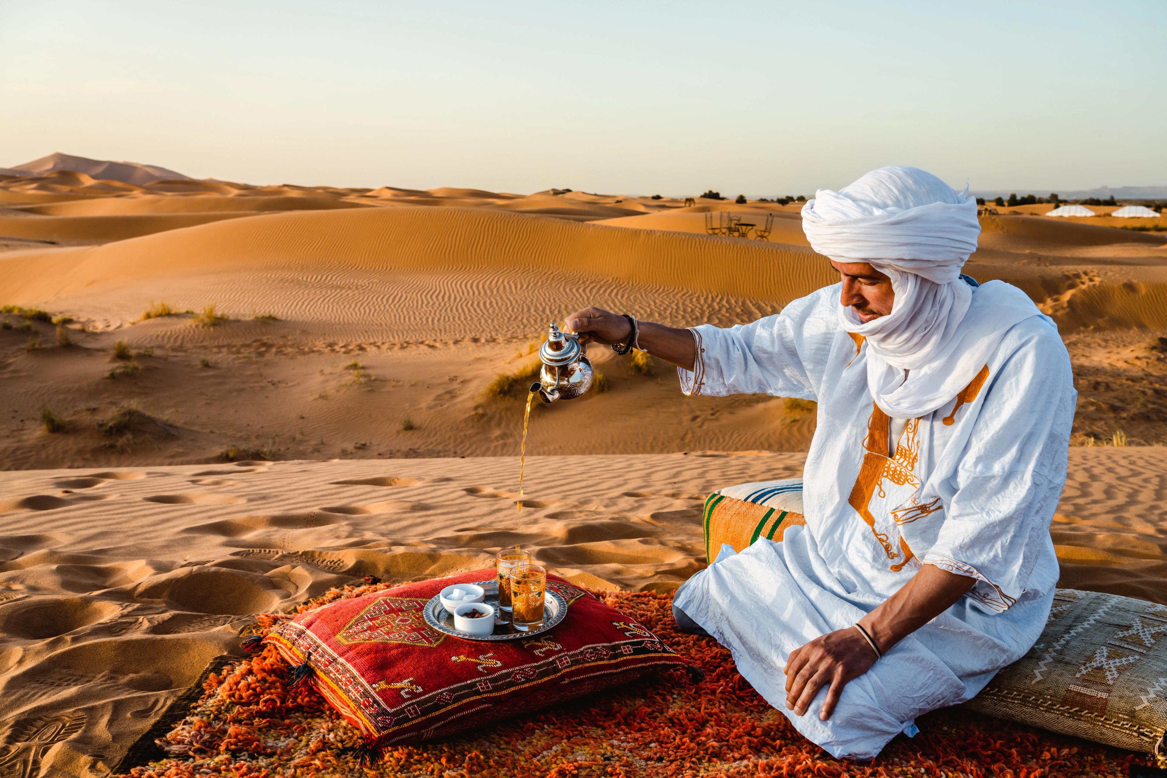 Berber man pouring tea in the dunes of Merzouga, Morocco/Getty Images