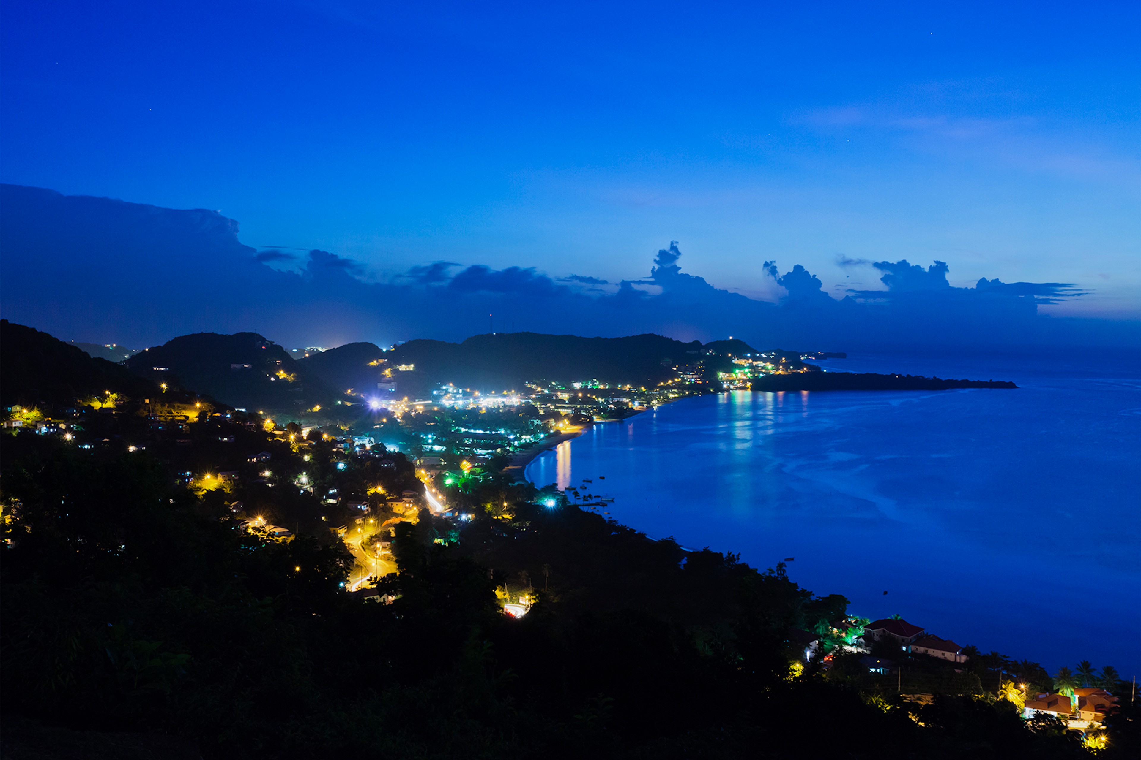 Grand Anse Bay at night seen from the hilltop of Jean Anglais. The bay is sheltered from high waves, strong currents and winds, so it is a favorite among tourists and locals./Getty Images