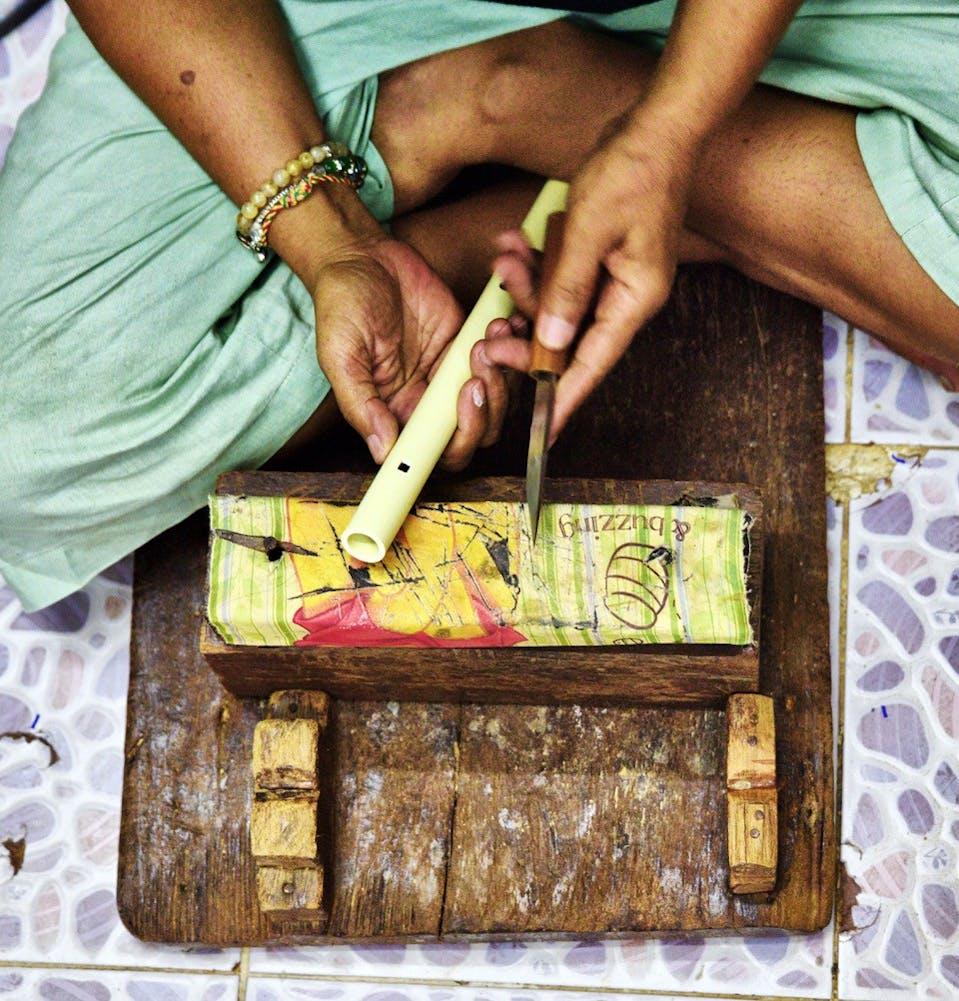 A flute maker demonstrates her skills in Bangkok./Ronan O'Connell