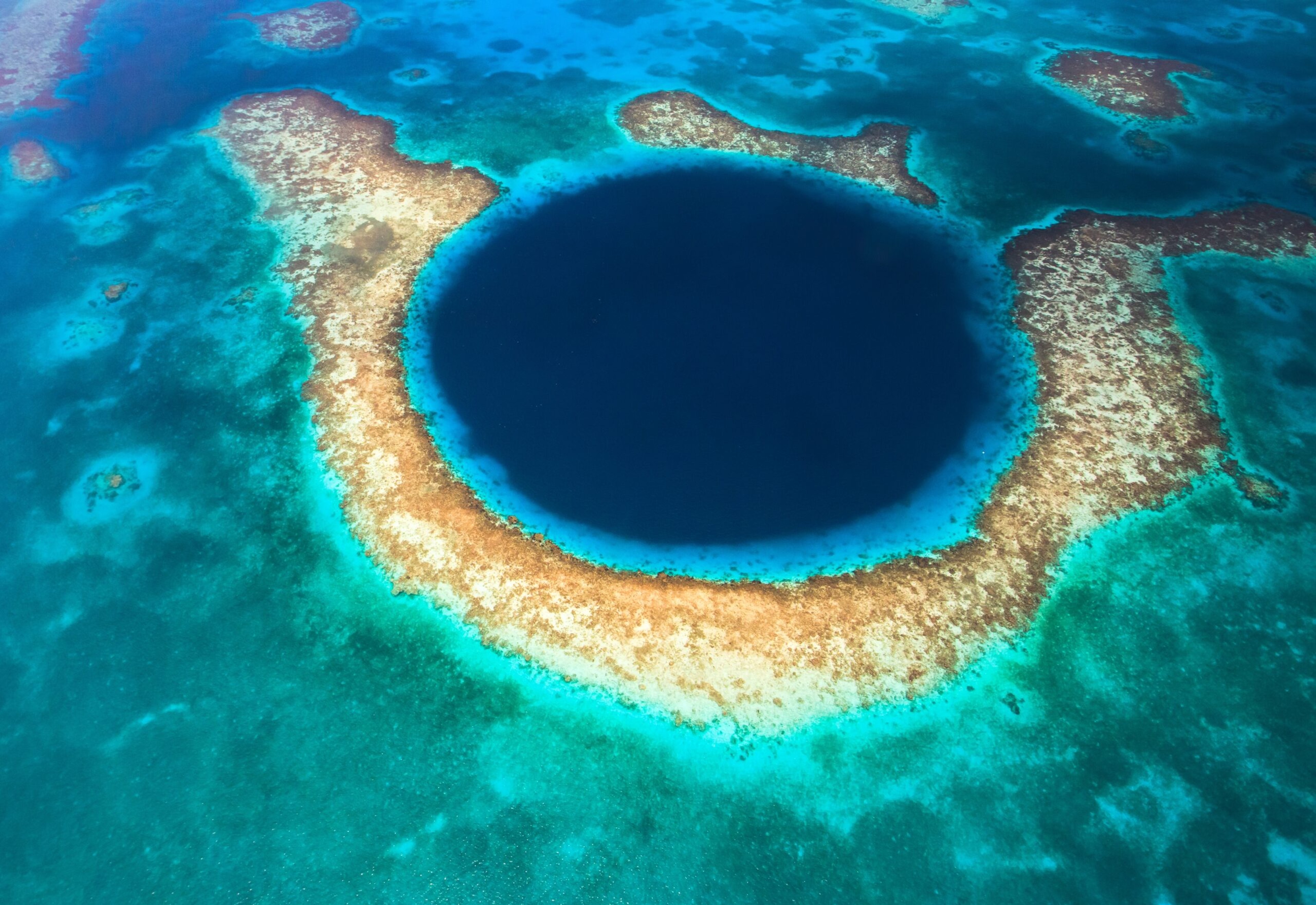 The Great Blue Hole, a vertical cave, lies about 60 miles off Belize and is a magnet for divers./Shutterstock