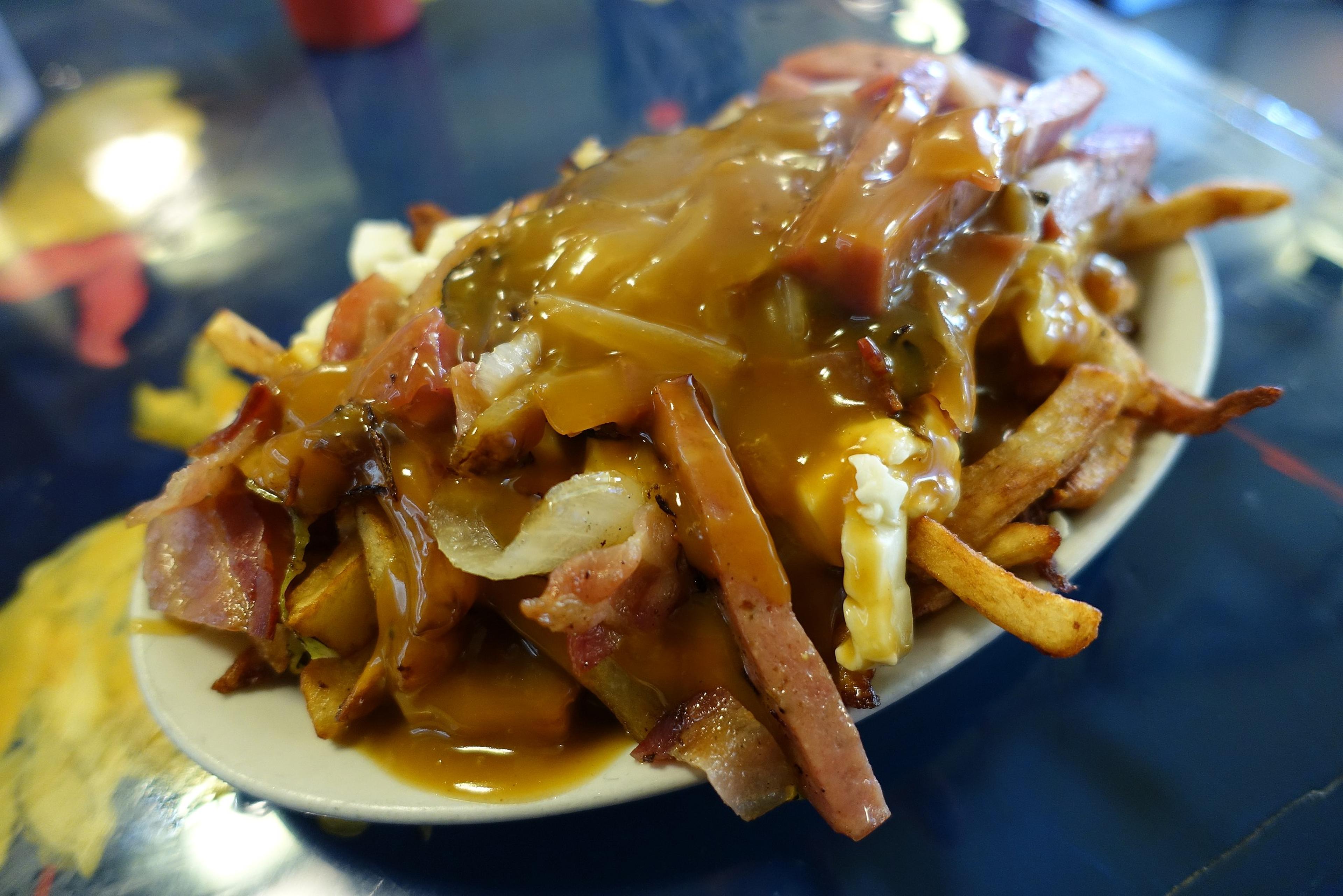 The late Anthony Bourdain called the poutine at Montreal's La Banquise a "thoroughly wonderful gastronomic train wreck."/Guilhem Vellut/Wikimieda Commons