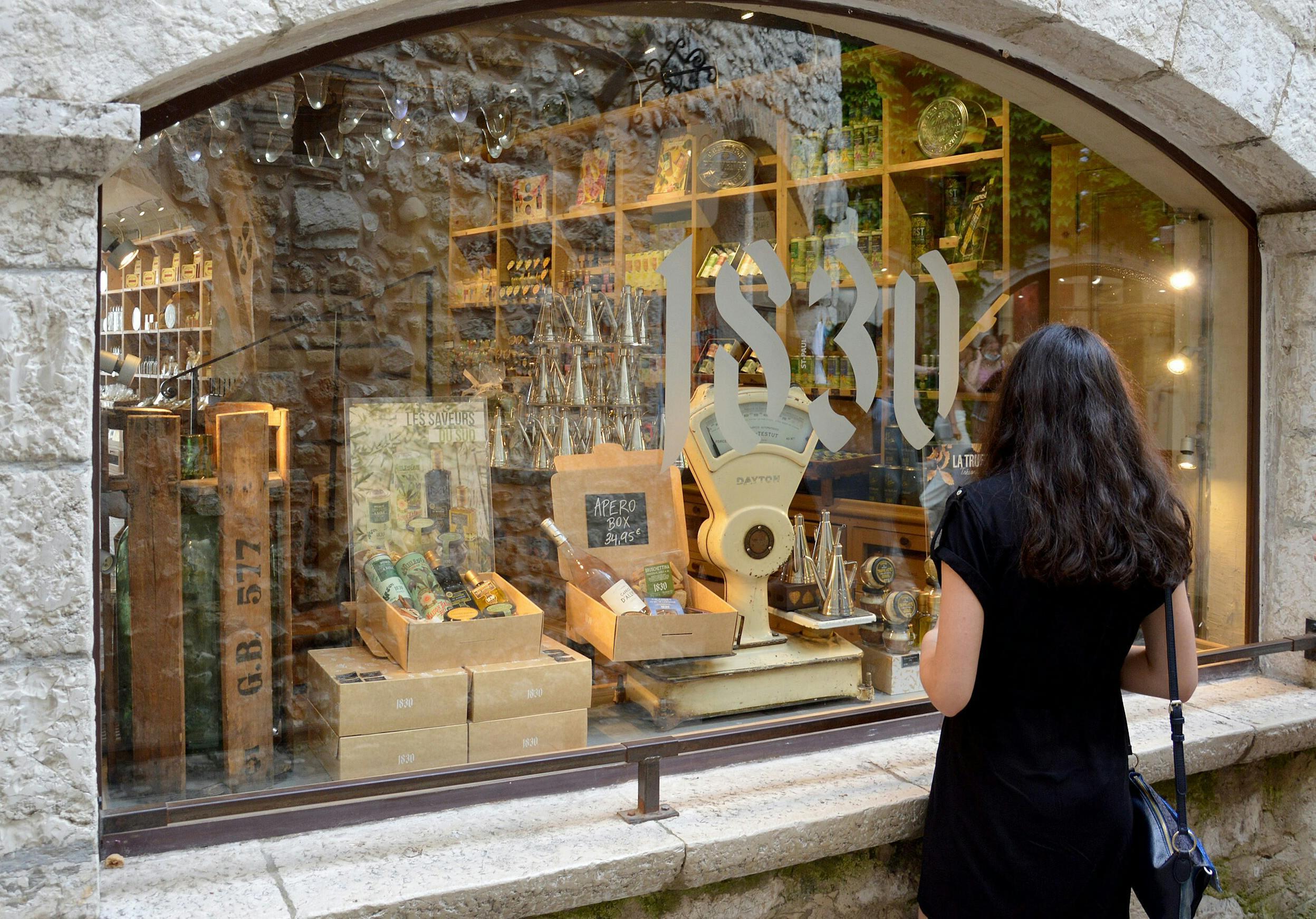 A visitor window shops at Maison Bremond 1830 in Saint-Paul de Vence, France/Wikimedia Commons photo by DimiTalen