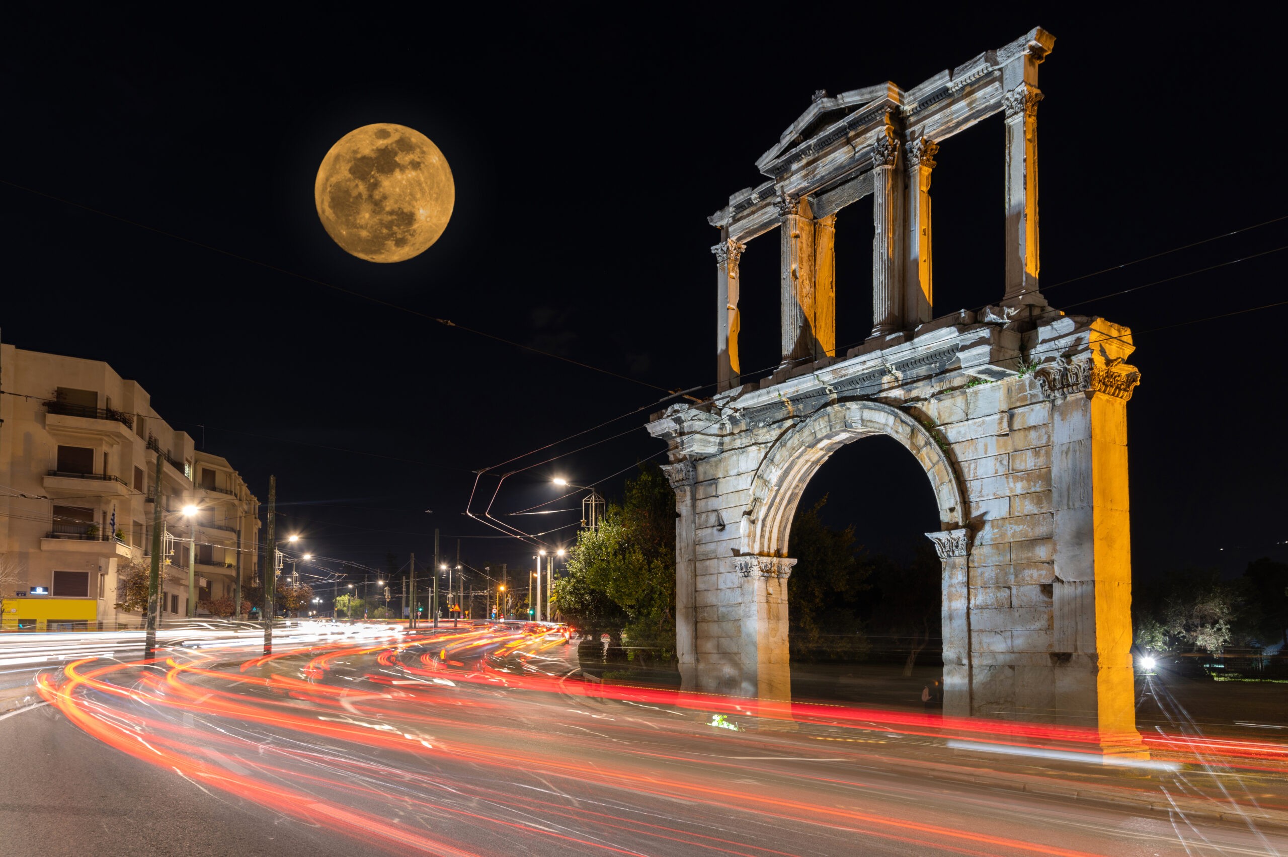 A full moon hovers over Hadrian's Arch in Athens. It was built in 131 or 132 CE and stands between the Acropolis and the Temple of Zeus./Getty Images