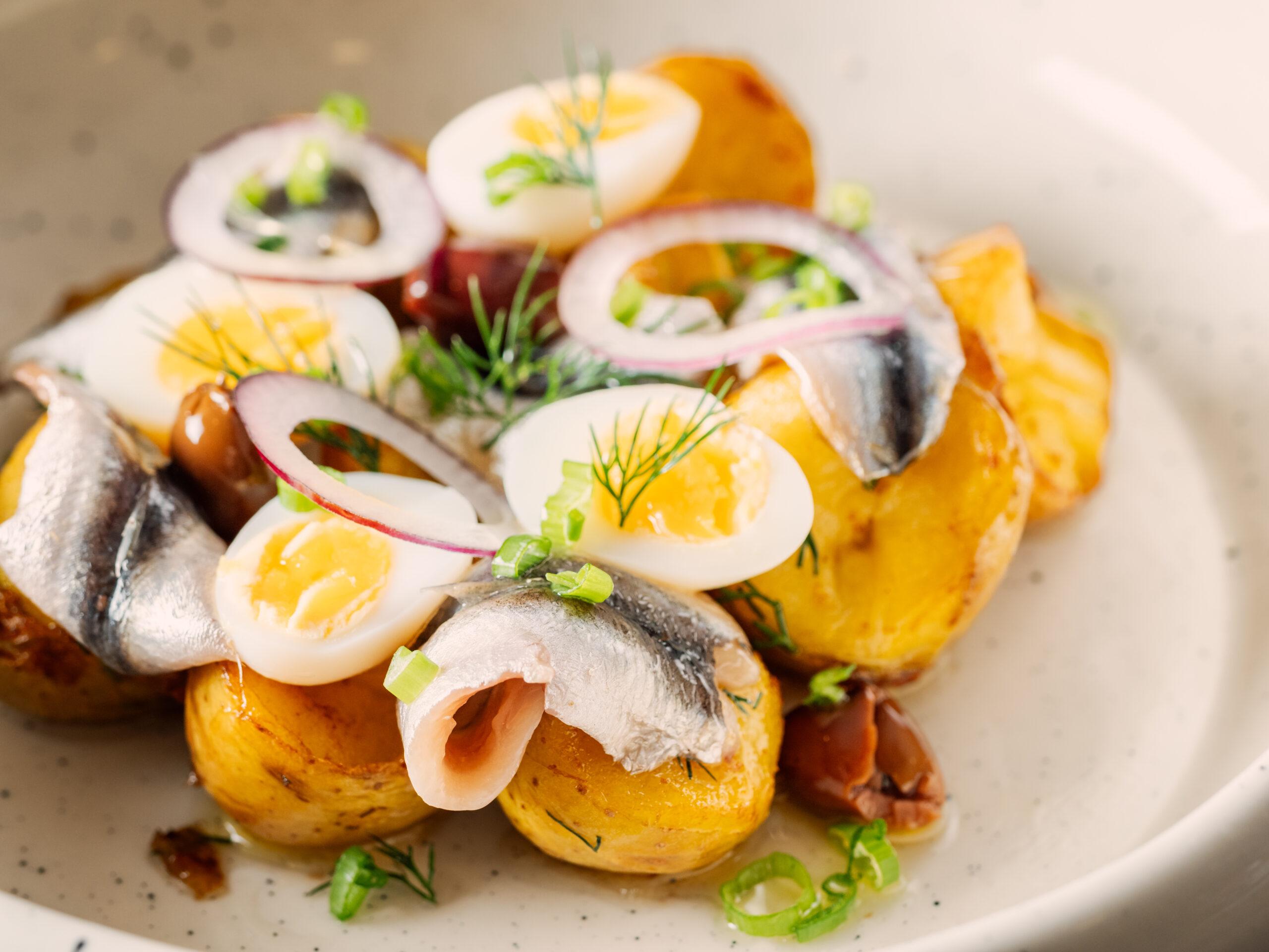 Sprat with potatoes with served onions and greenery/Getty Images