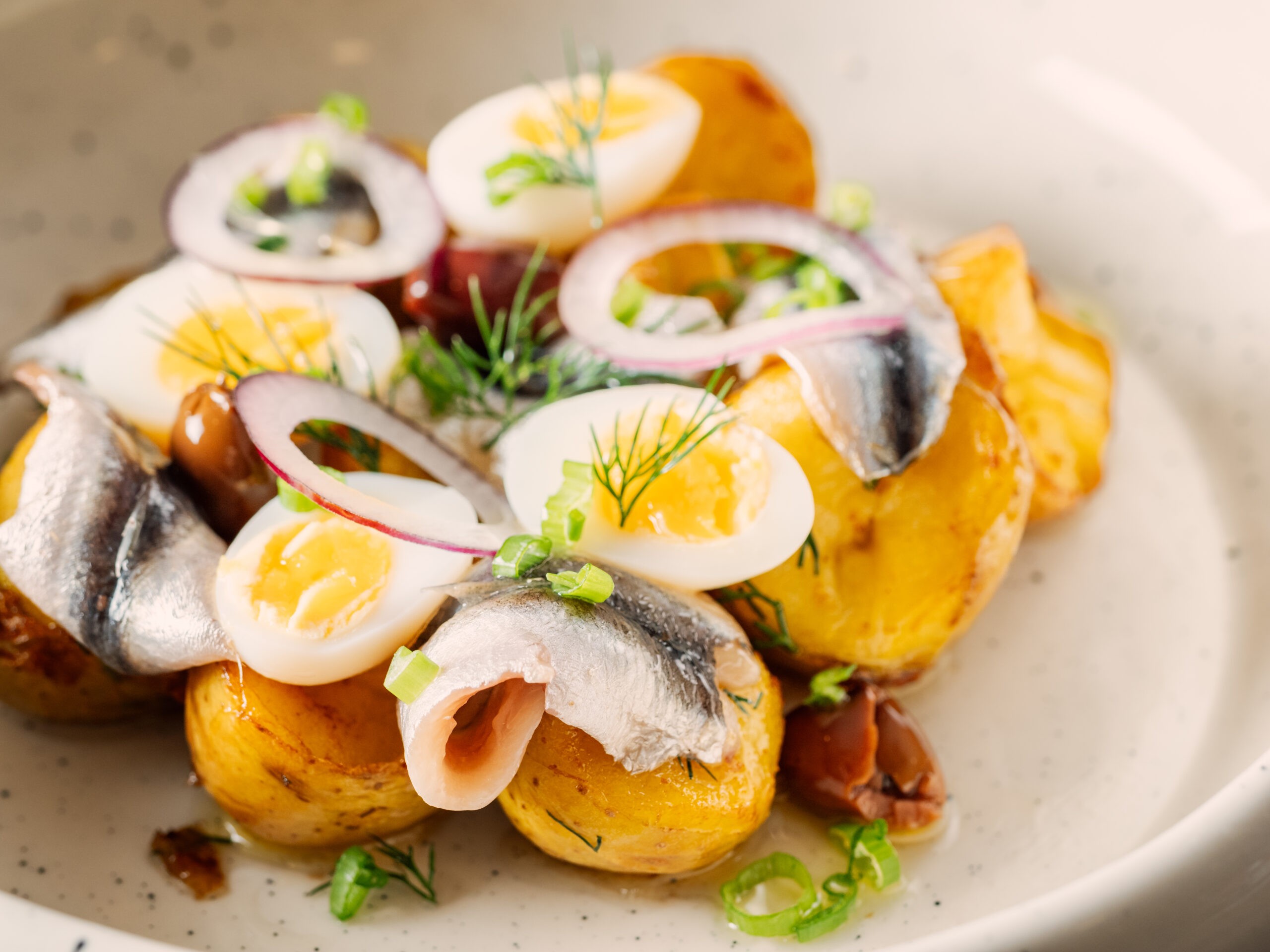 Sprat with potatoes with served onions and greenery/Getty Images
