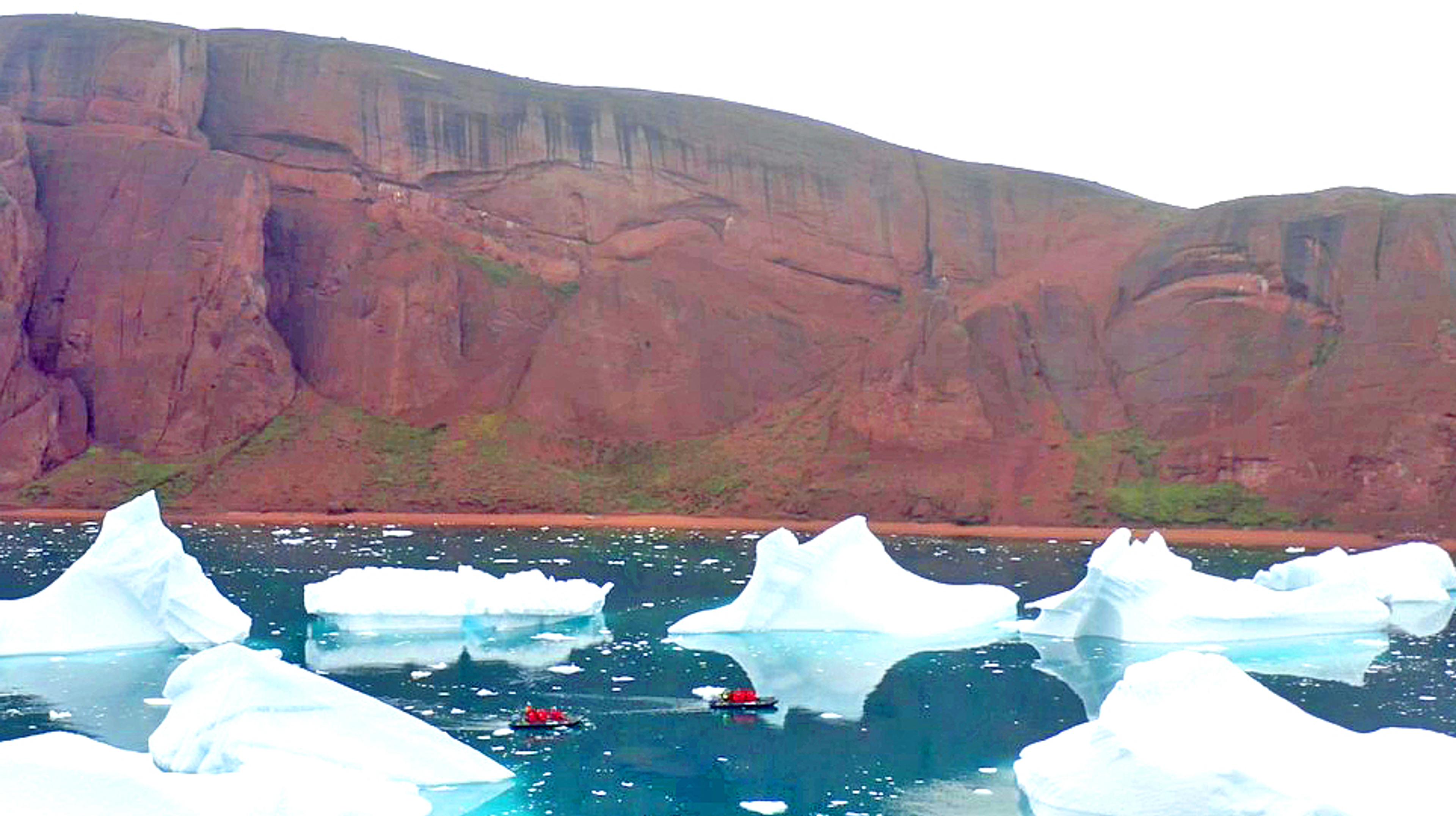 Zodiacs compete for color as they move around Red Island, Greenland./Ross McDonald for Silversea