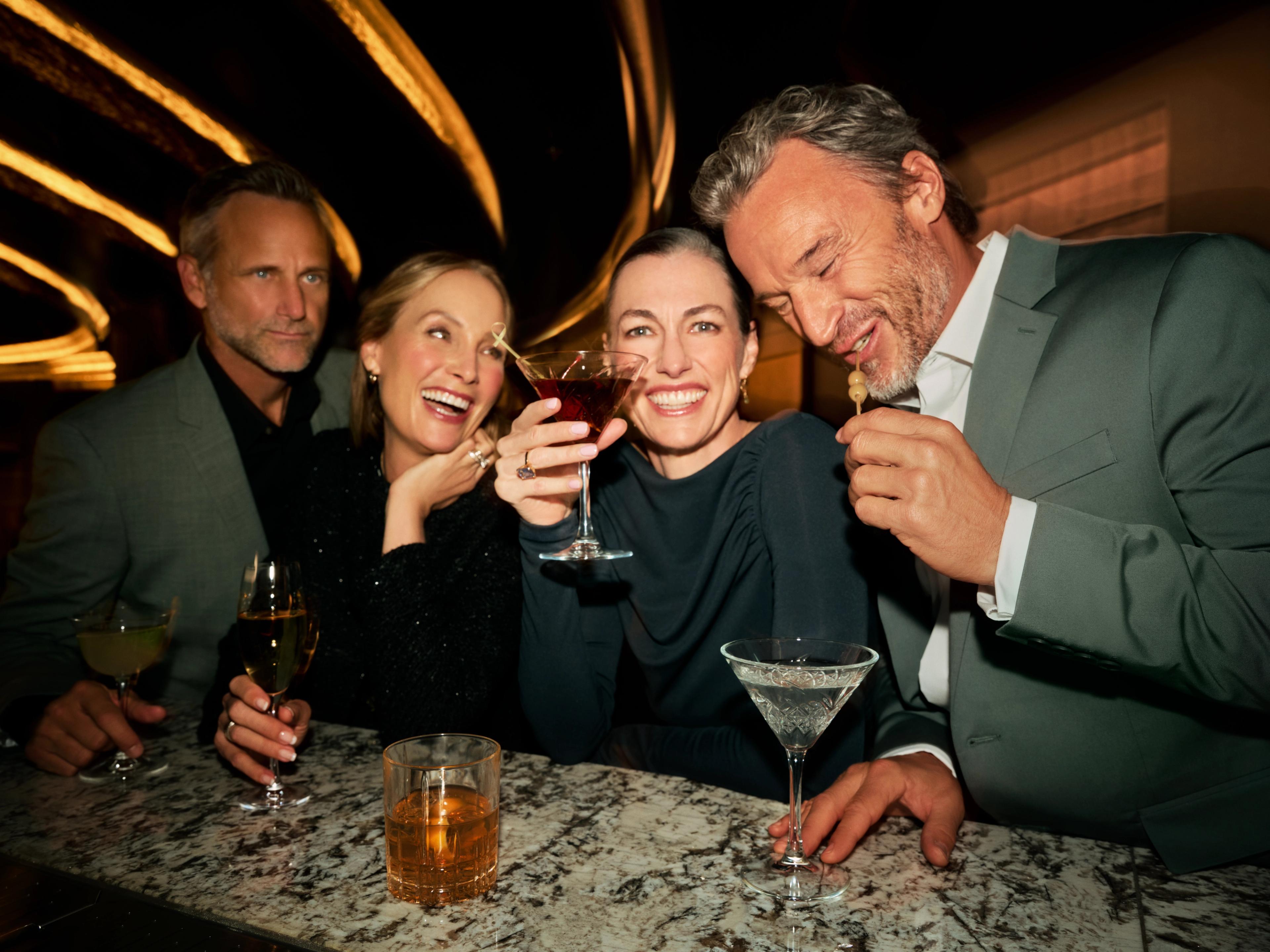 Four guests enjoying handcrafted cocktails and conversation aboard Silver Note.