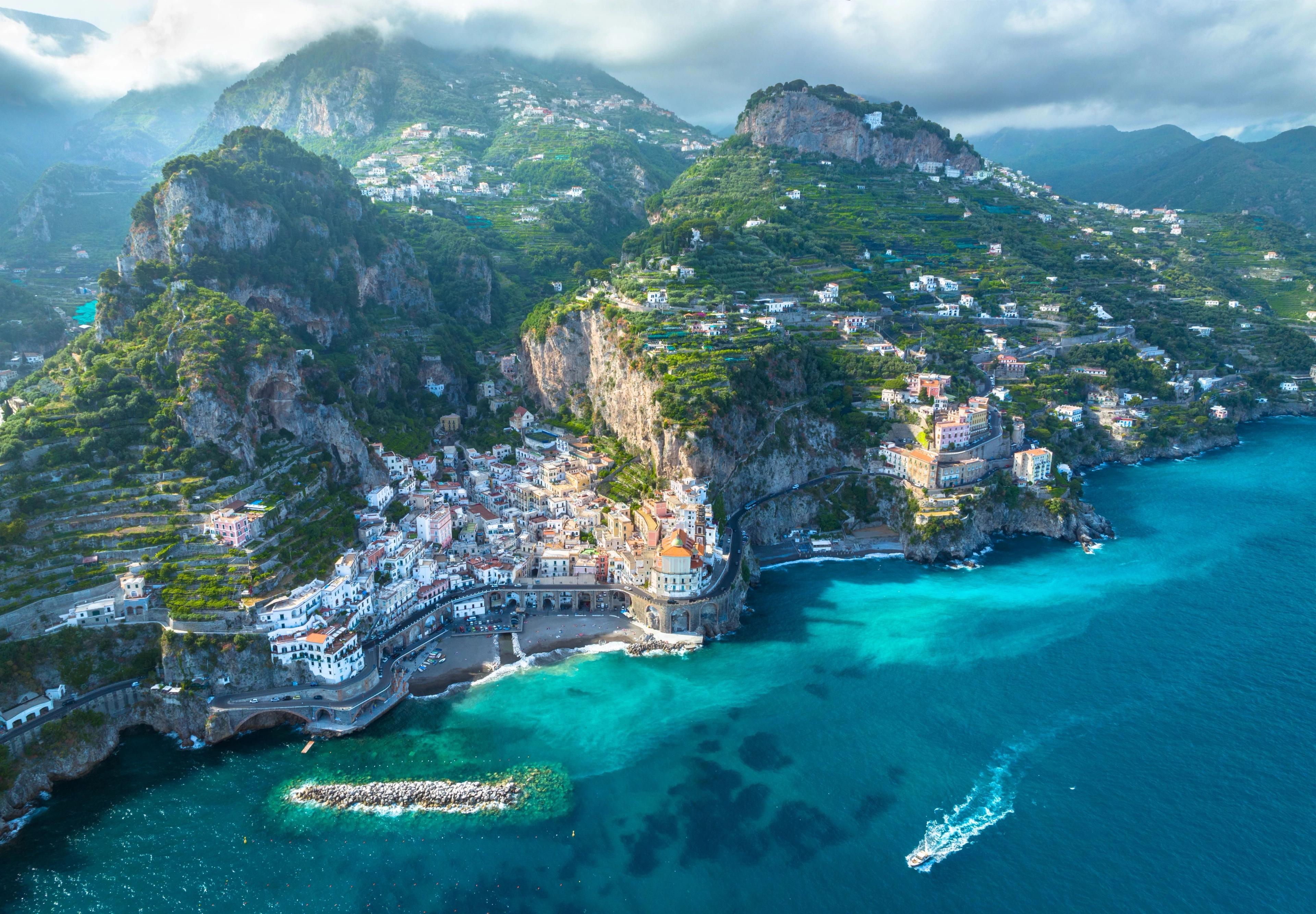 Amalfi cliffside village showcasing stacked colorful houses overlooking deep blue Mediterranean waters. 