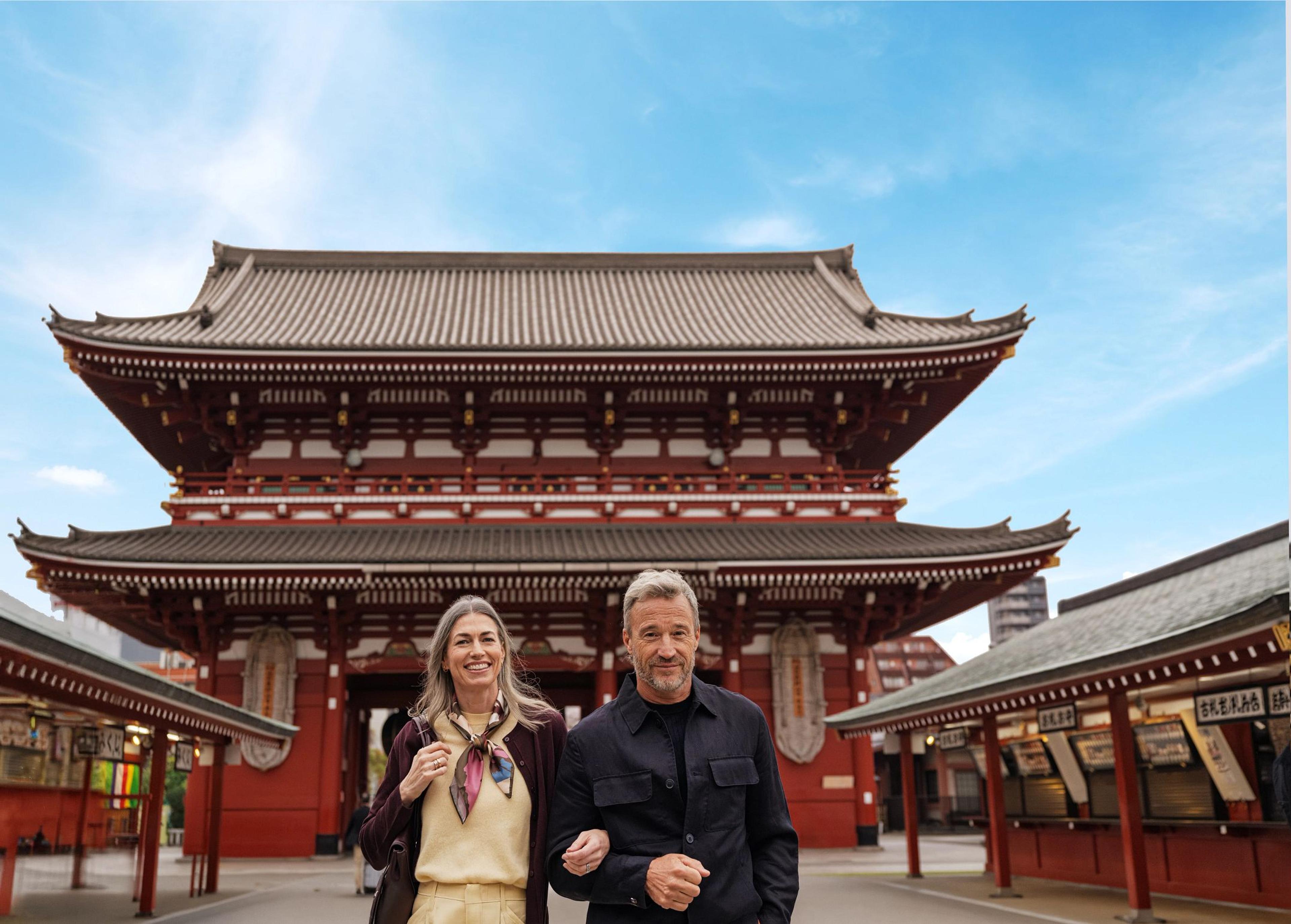 A couple meanders through the ancient Sensō-ji temple, experiencing Tokyo's timeless spiritual heritage.