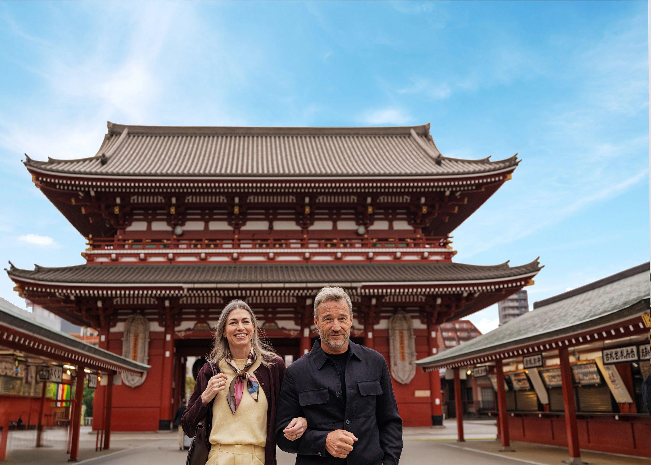 A couple meanders through the ancient Sensō-ji temple, experiencing Tokyo's timeless spiritual heritage.
