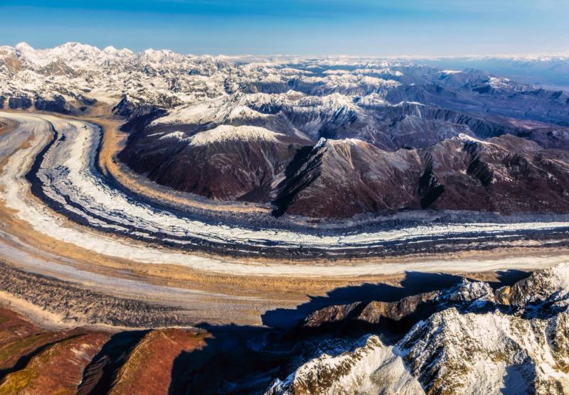 Glaciers winding between snow-capped mountains in Alaska, seen from the air