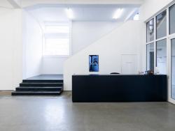 Frontalansicht, schwarze Treppe und Tresen, sowie einem Screen.