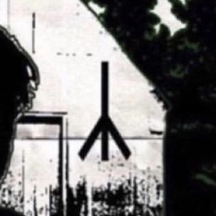 Une rune de la mort sur un hangar derrière Ted Kaczynski.