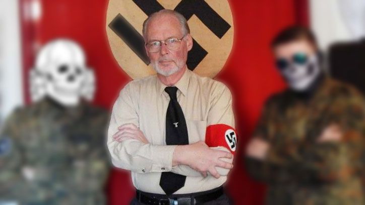 Une photo de James Mason portant un brassard à croix gammée nazie. Derrière lui se trouve un drapeau à croix gammée nazi. En arrière-plan flou, deux hommes vêtus d'un équipement paramilitaire.