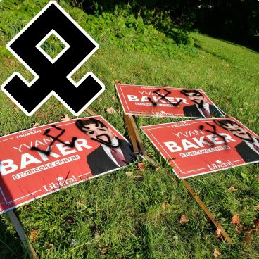 An Odal Rune is placed for reference in the corner of a photograph of defaced campaign signs for Yvan Baker. The signs were defaced by Odals.