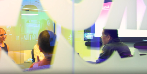 Looking through a meeting room window, where employees have meeting