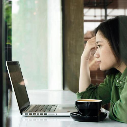 A girl looking at her laptop, reading information on her ID theft protection service. picture.