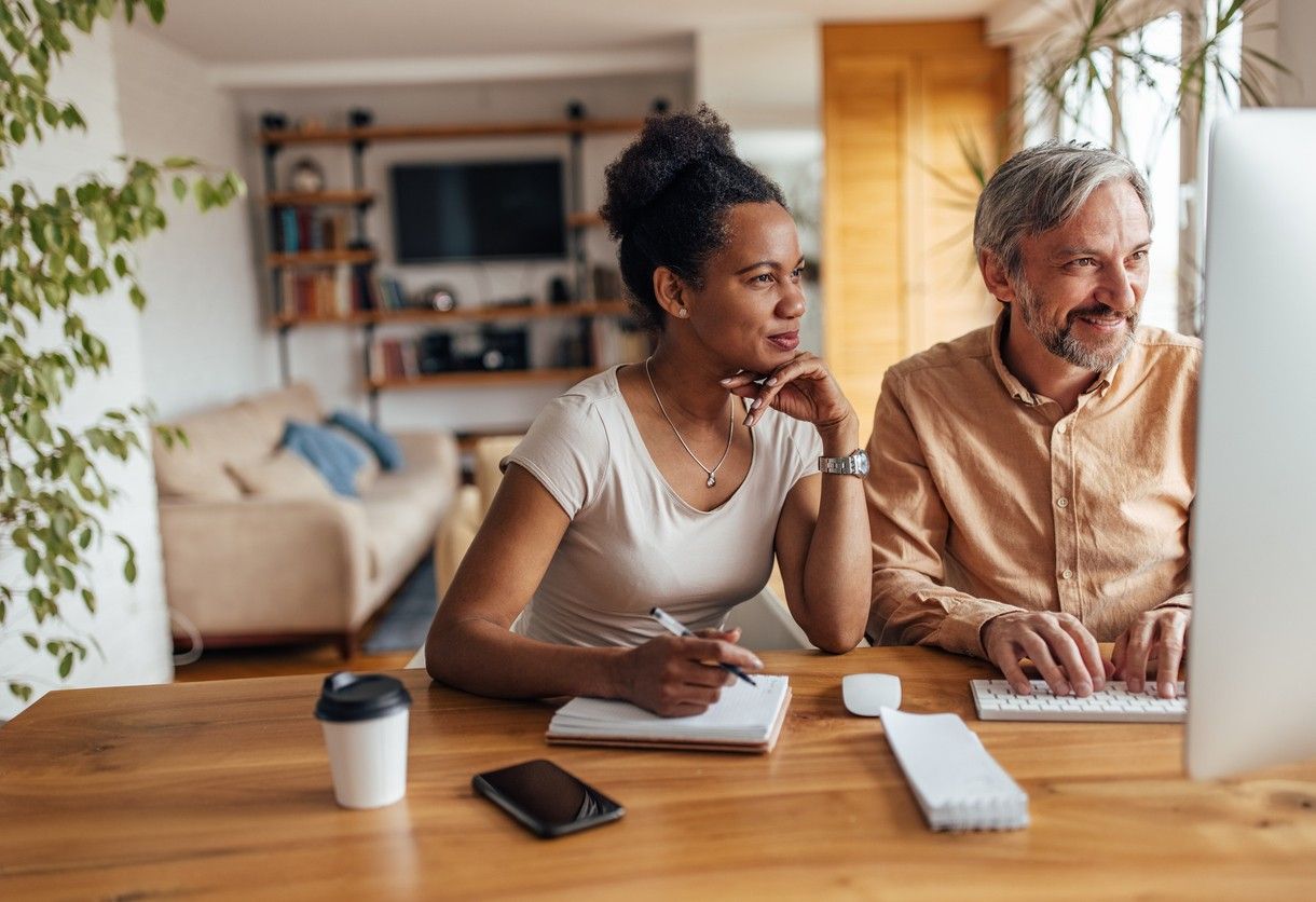 Dame og mann sitter ved pc og ser over den personlige økonomien sin. bilde