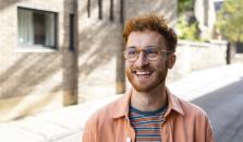 Rödhårig man ute på gatan. Solen skiner. foto.